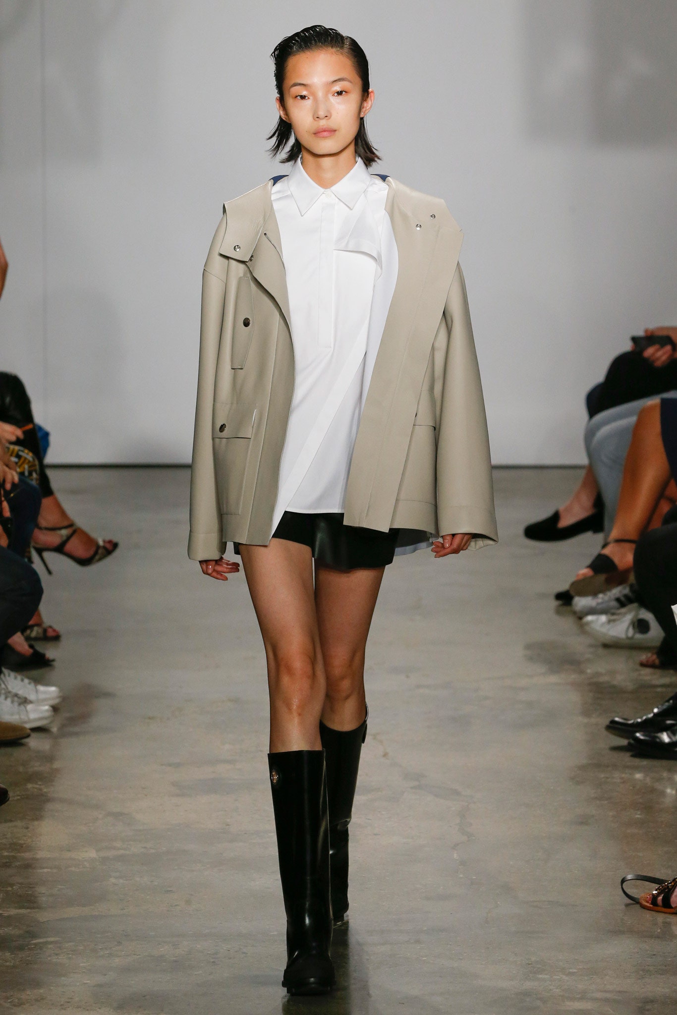 beige vinyl coat with black leather shorts