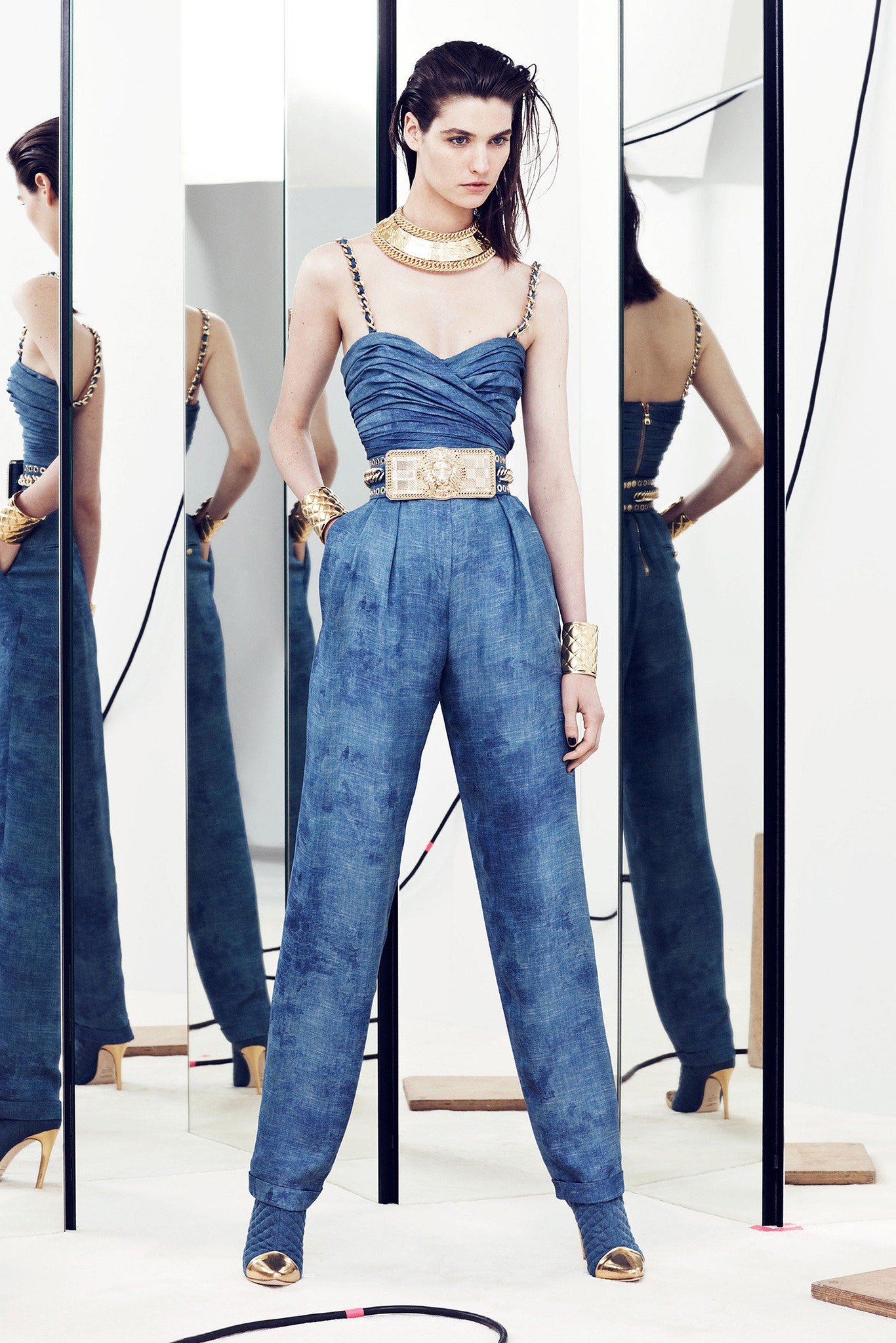 blue fitted jumpsuit with gold accessories