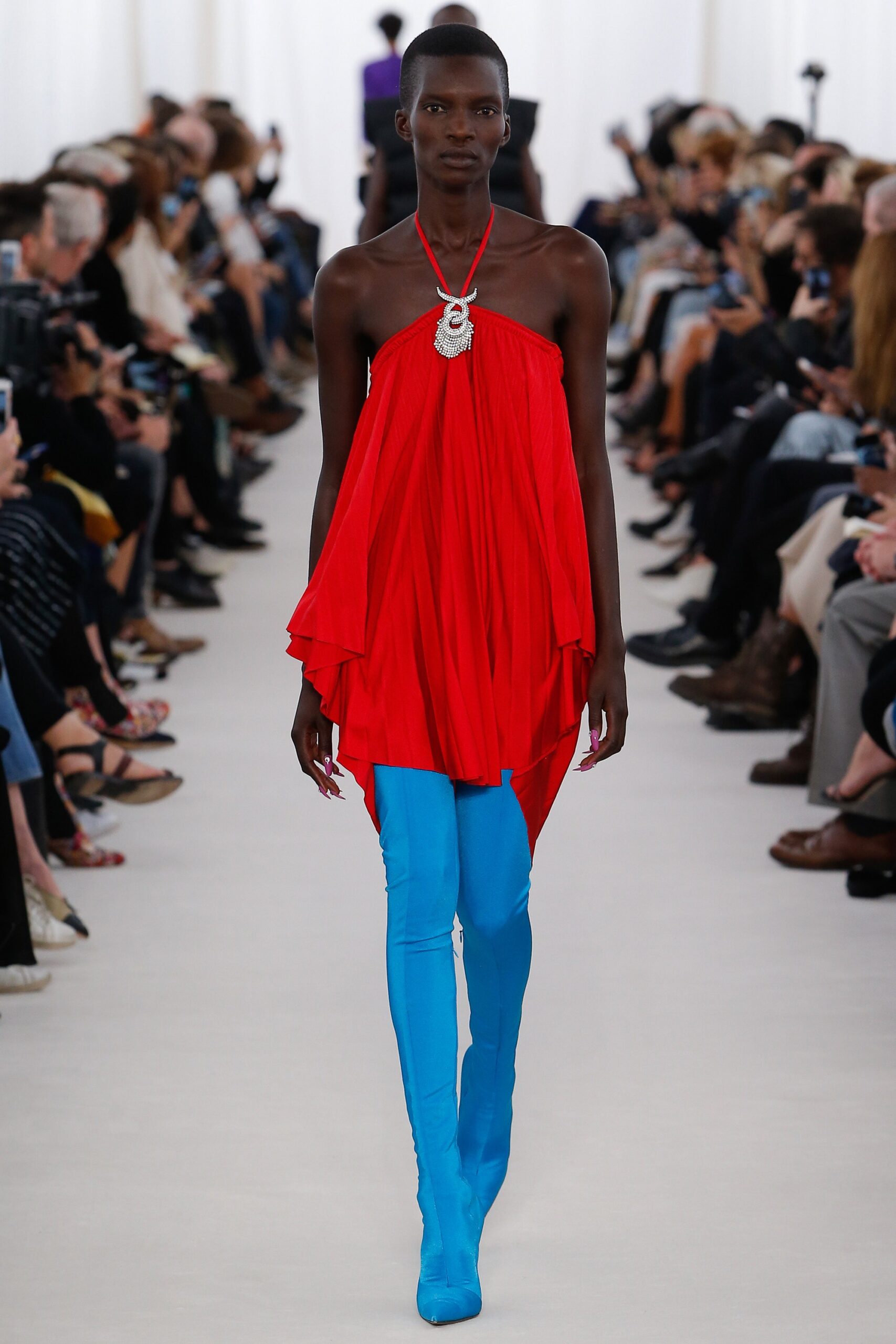 red draped dress with blue pants