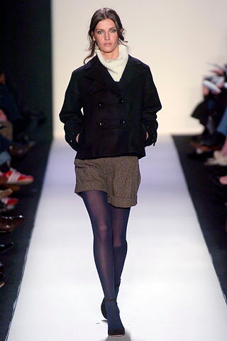 black jacket with white turtleneck and brown shorts