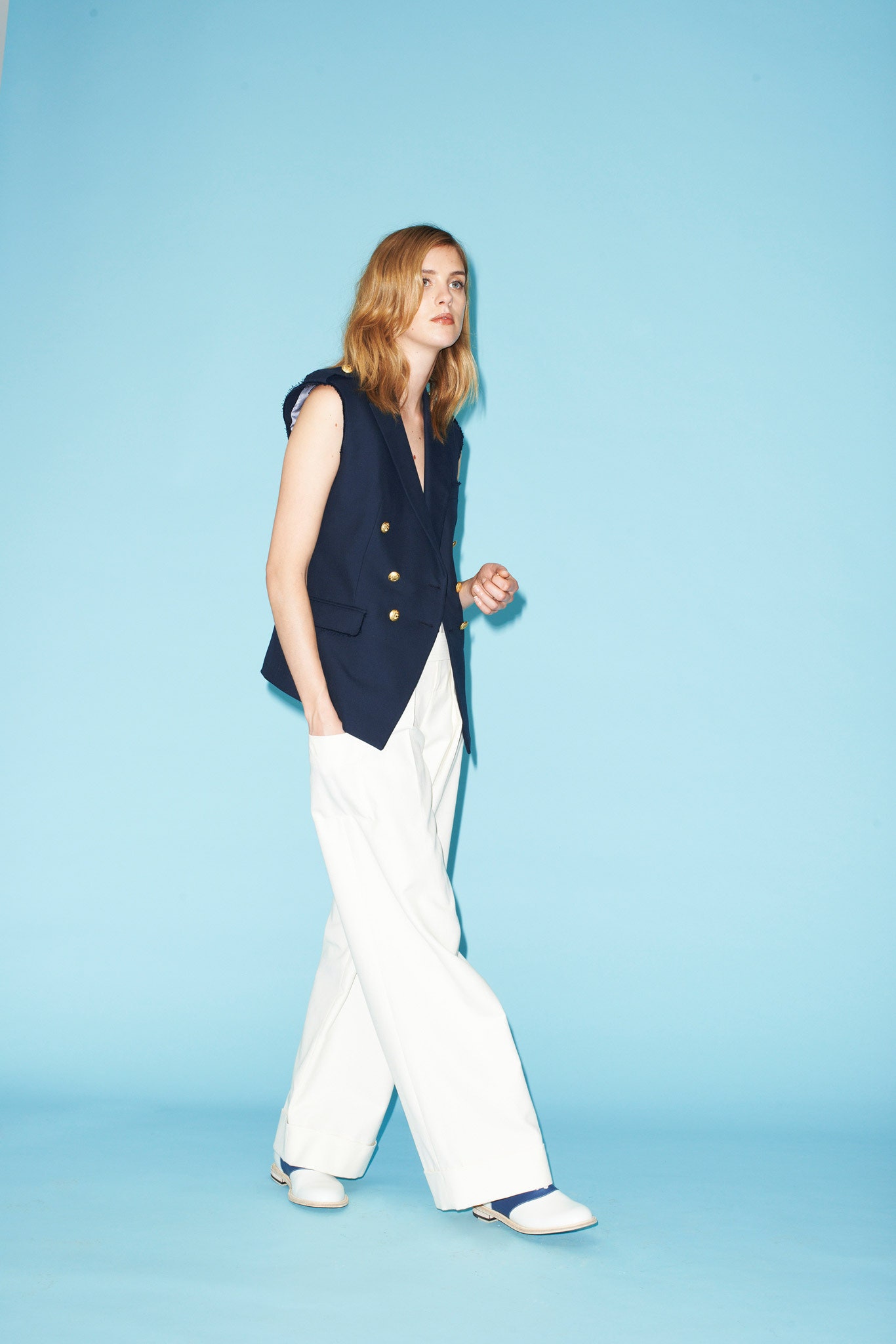 blue fitted vest and white wide-leg pants