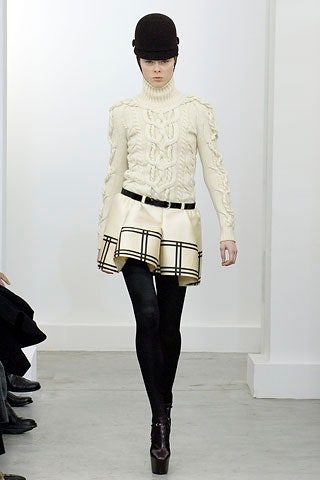 white fitted sweater and beige pleated skirt