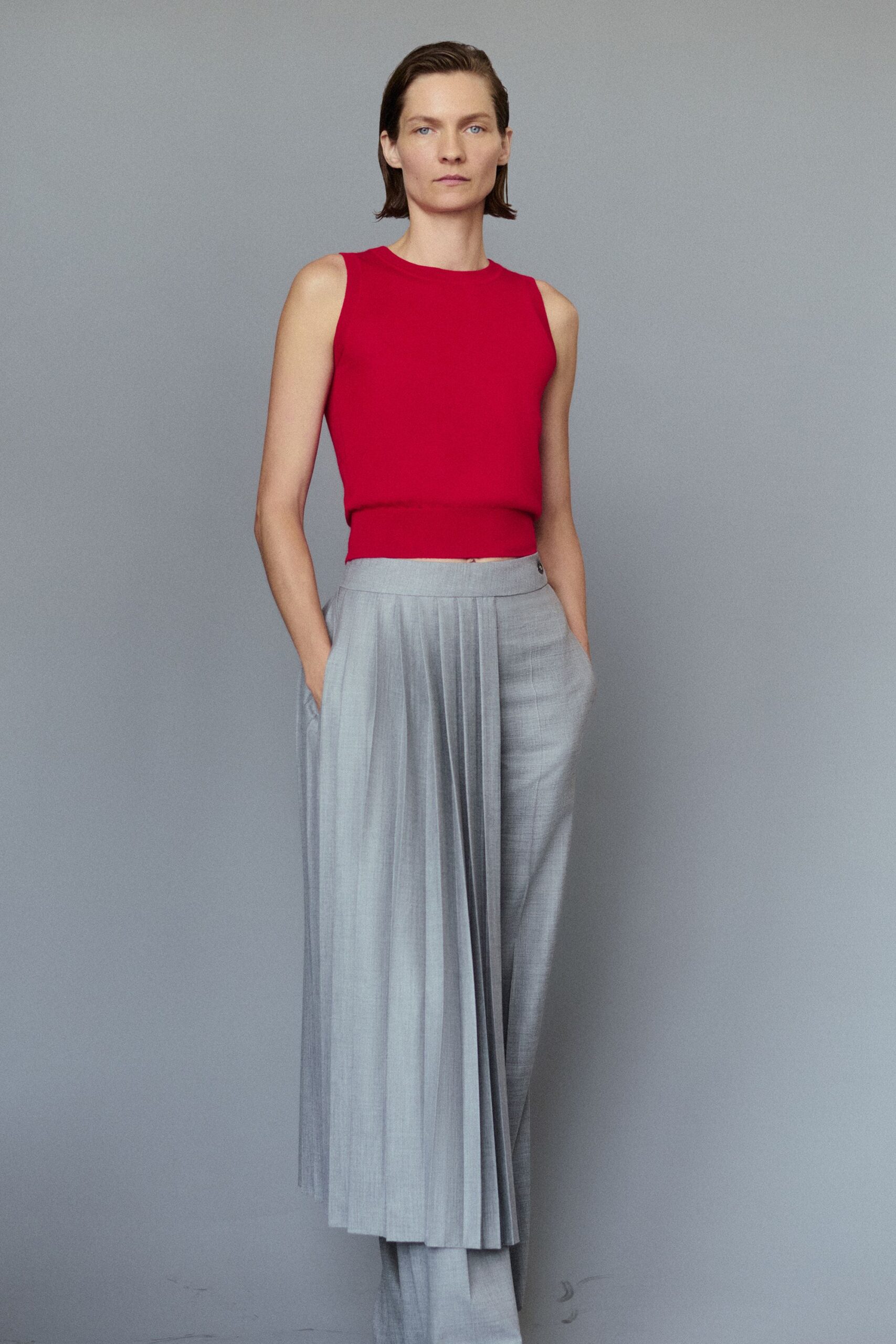 pink sleeveless top with gray pleated pants