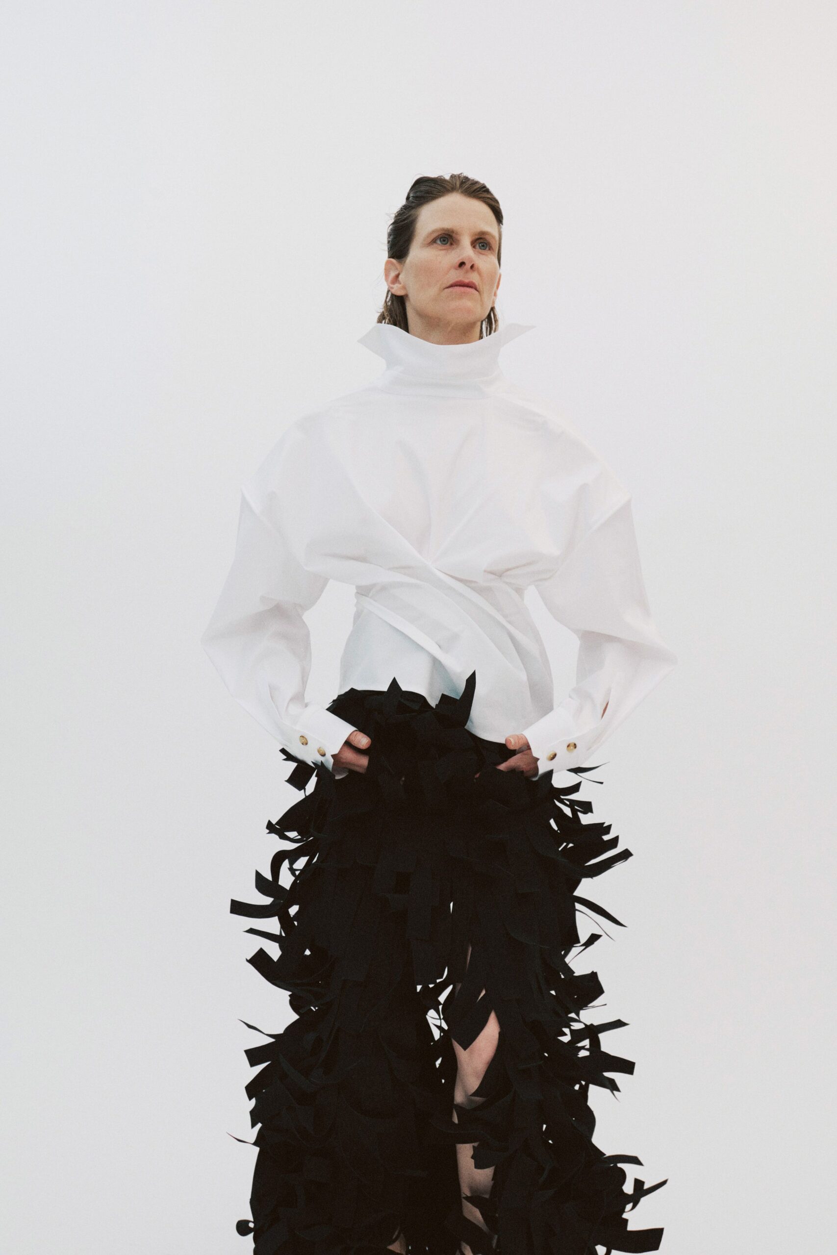 white relaxed top and black fringed pants