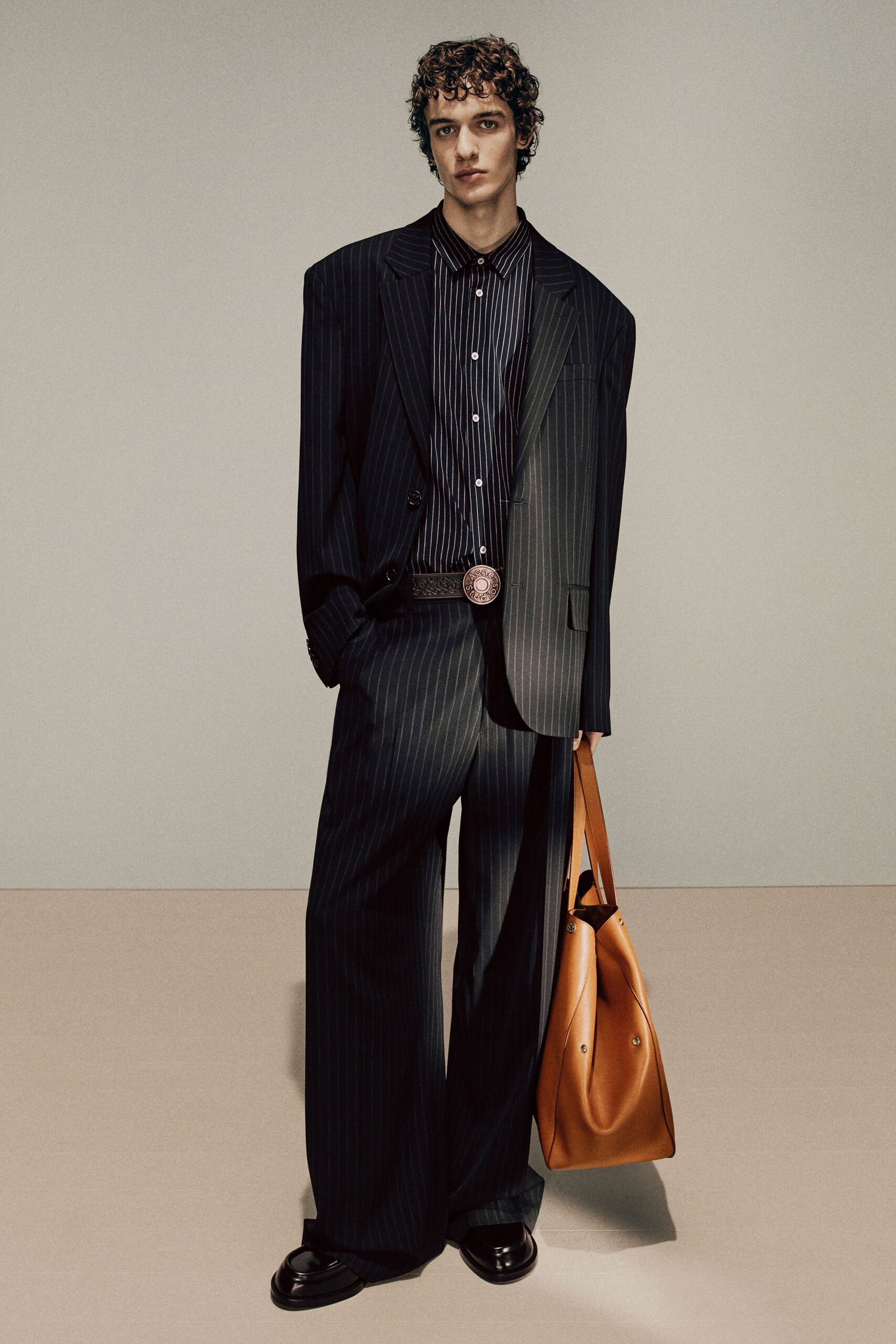 black striped suit with brown bag