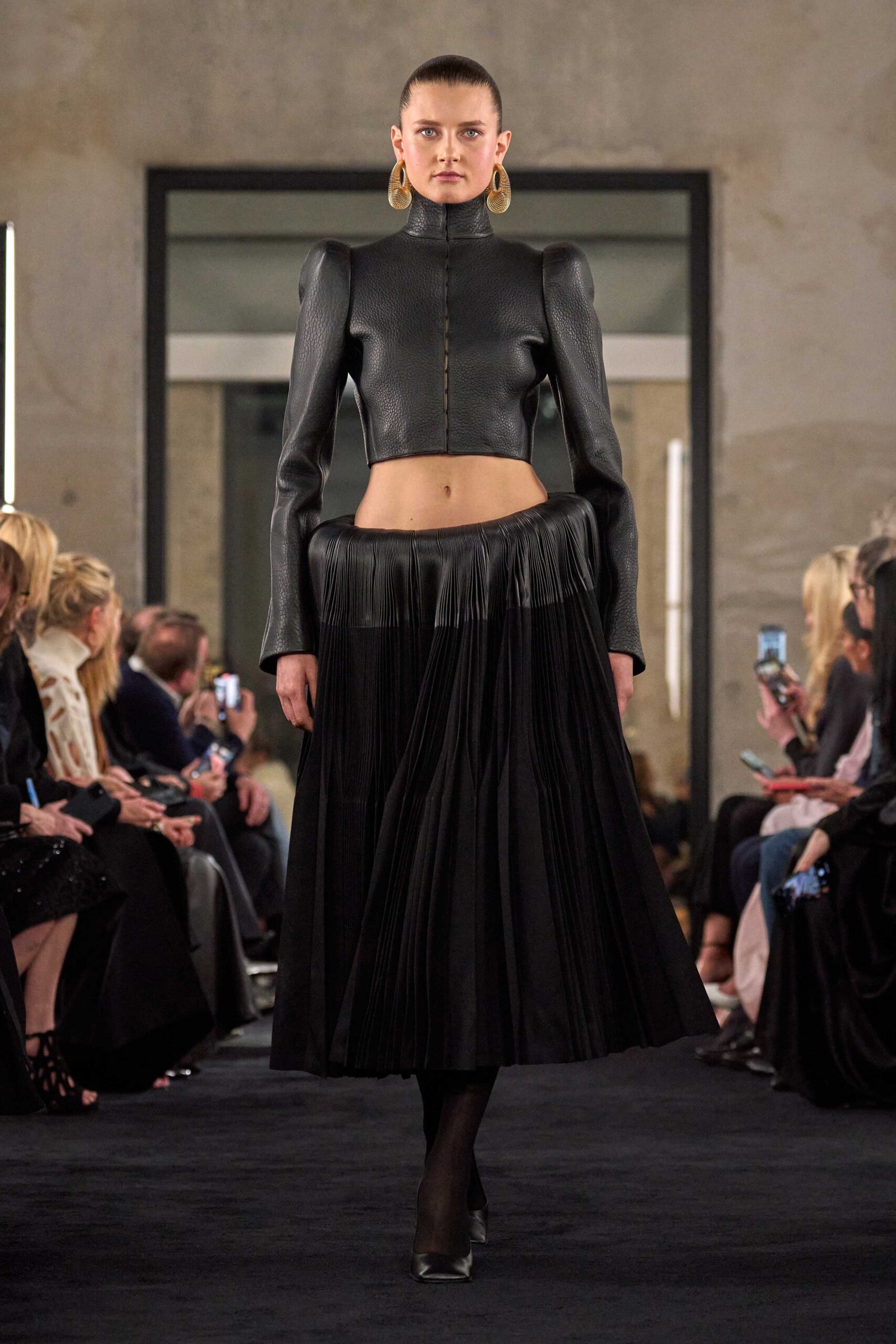 black leather cropped top and pleated skirt