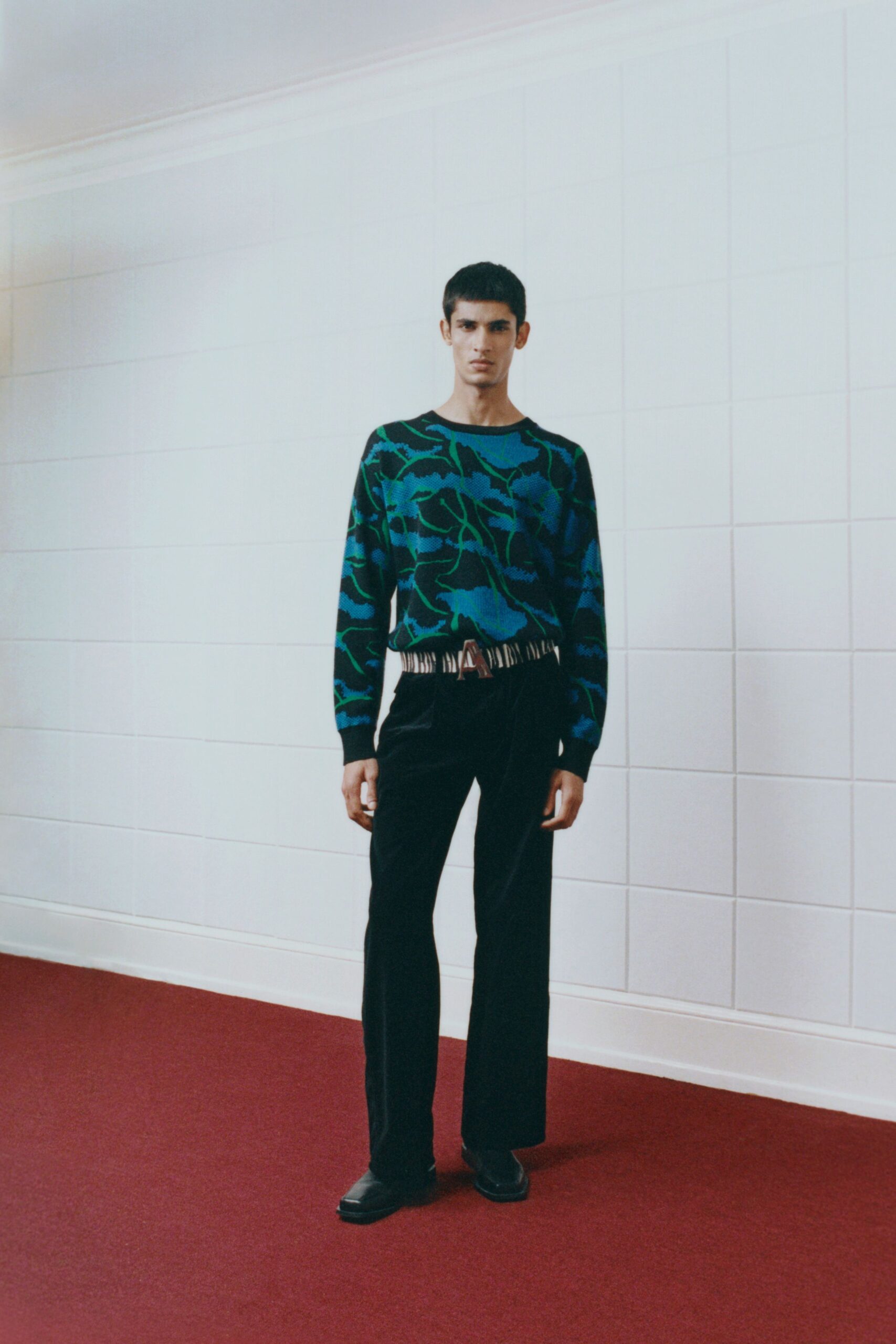 blue green printed sweater with black pants