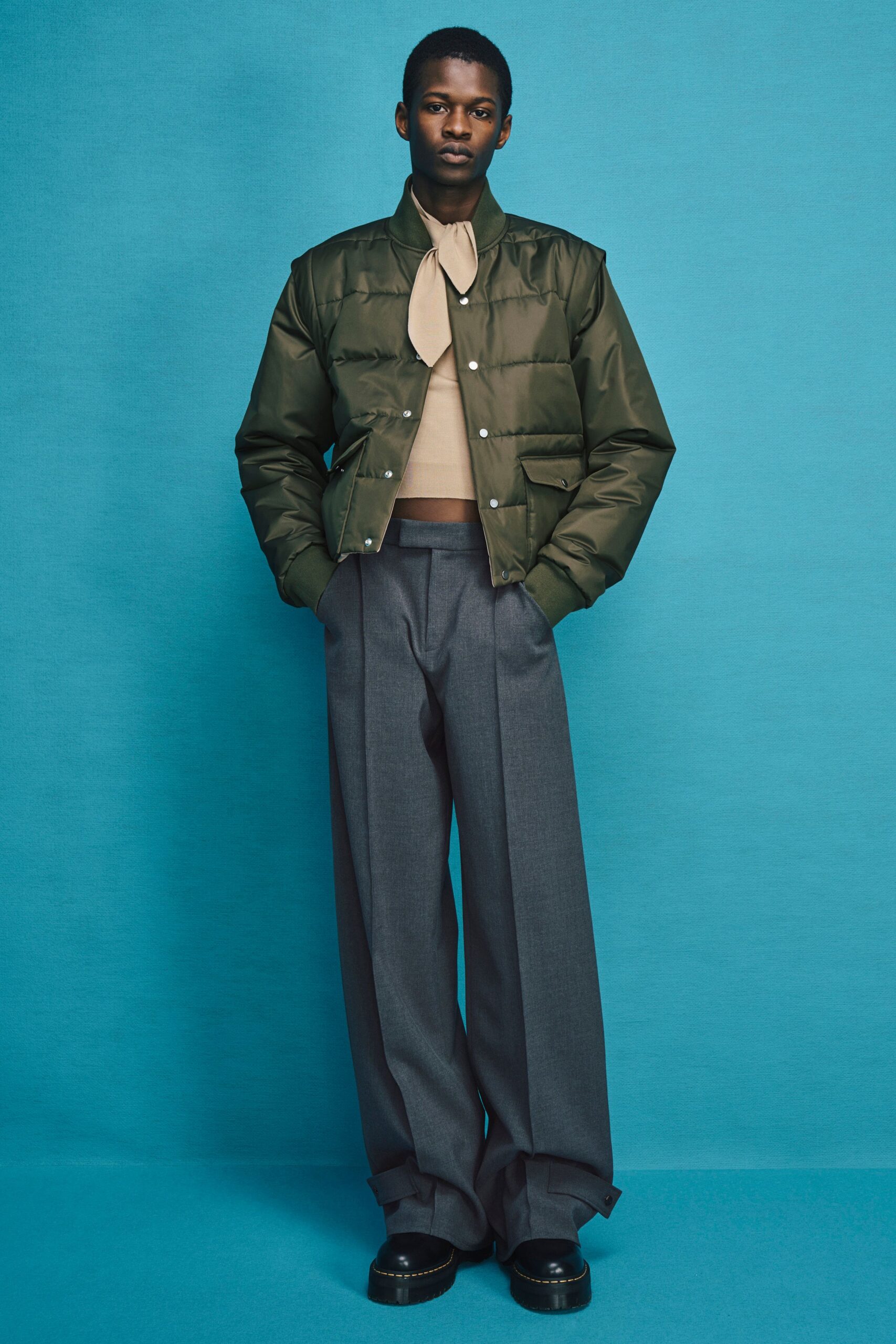green jacket beige top gray pants