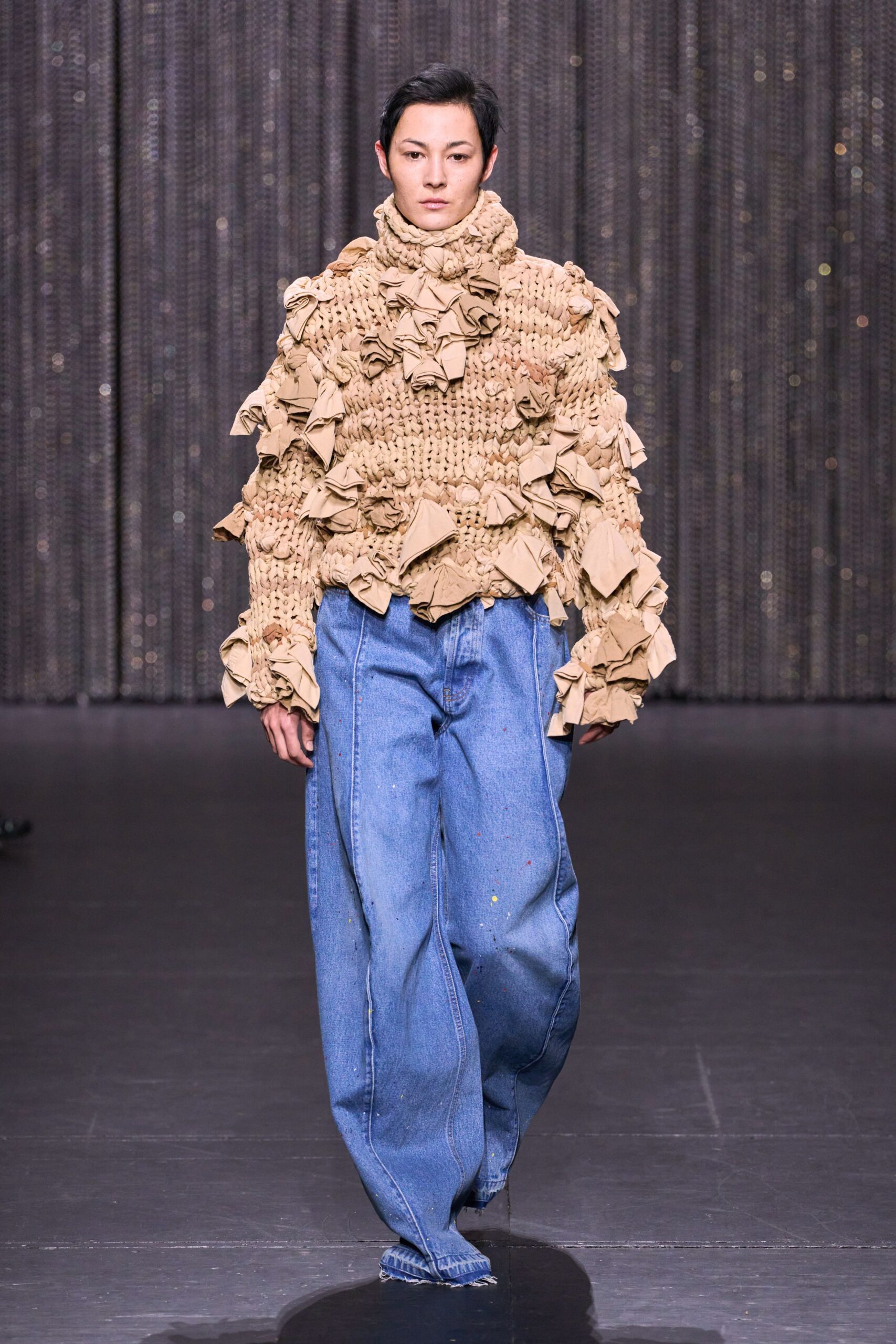 beige oversized ruffled sweater and blue denim pants