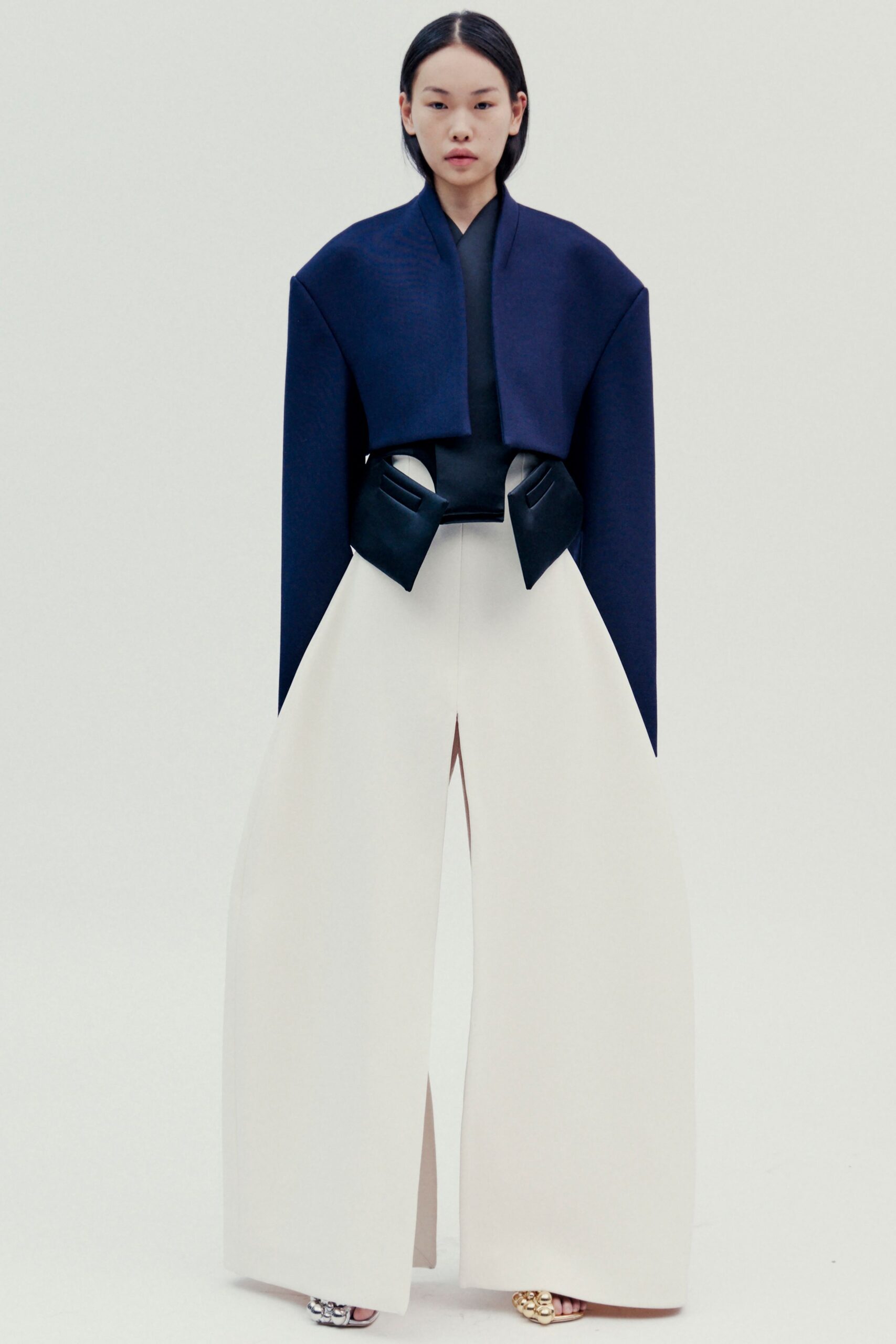 navy cape black top white wide-leg pants