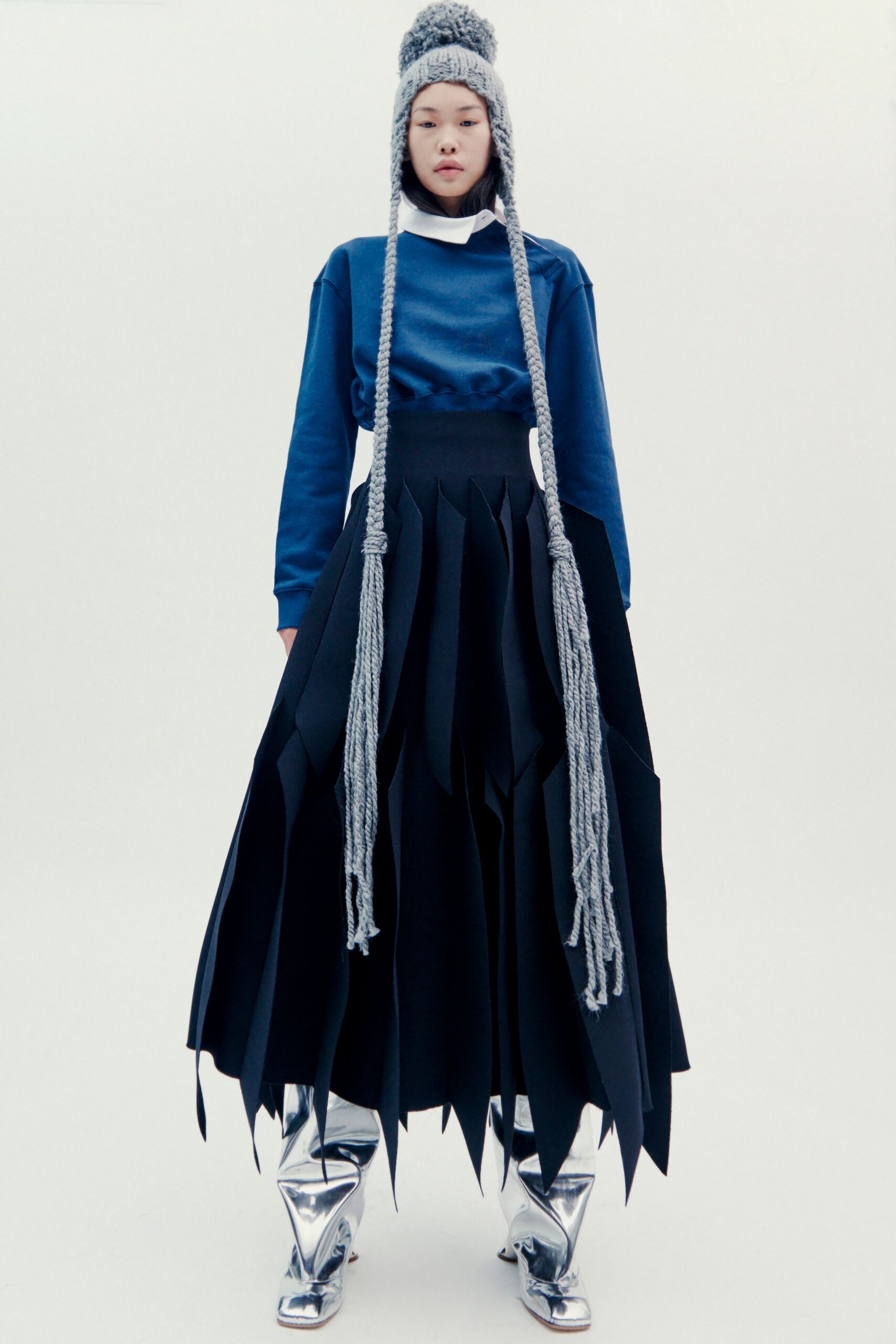 blue relaxed top with black pleated skirt