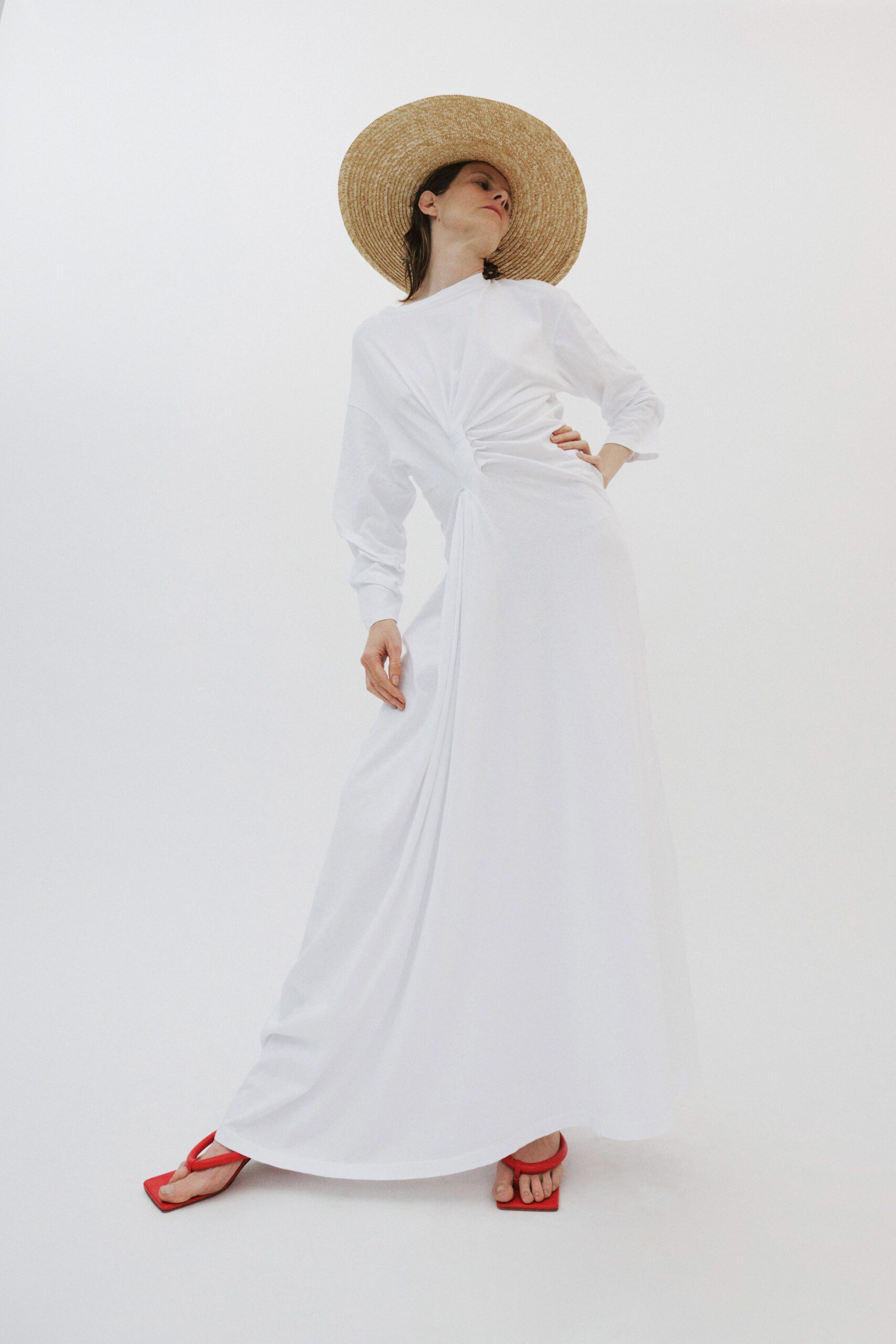 white fitted gown with wide-brimmed hat