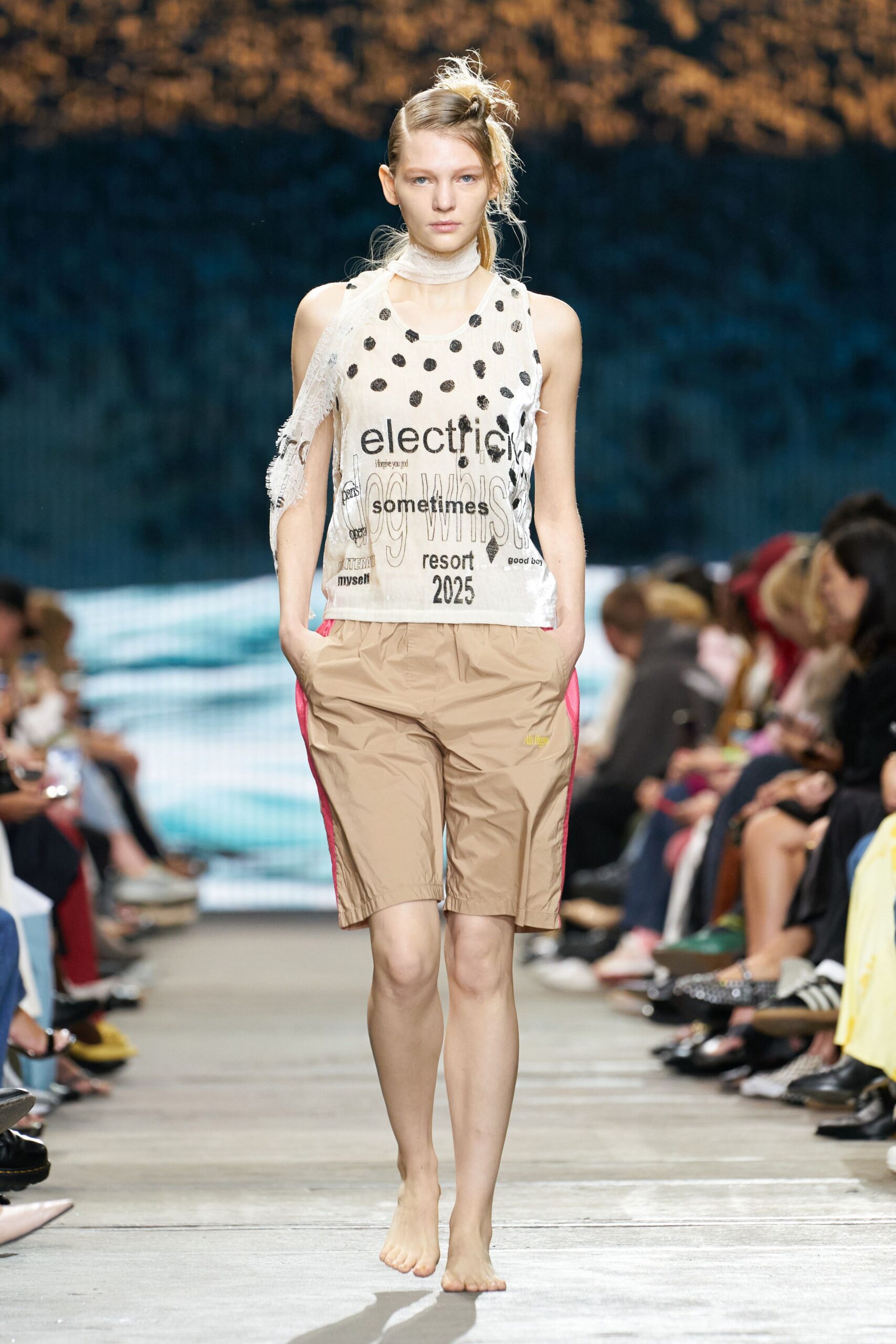 white printed sleeveless top and beige shorts