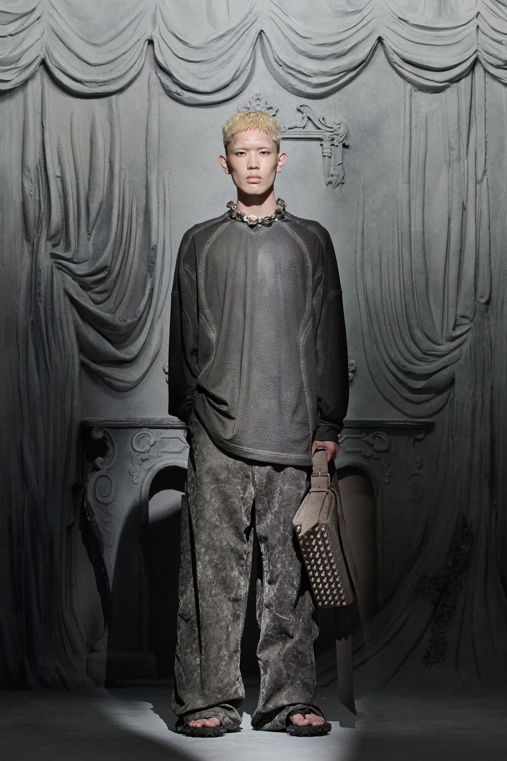 black leather relaxed top and gray pants