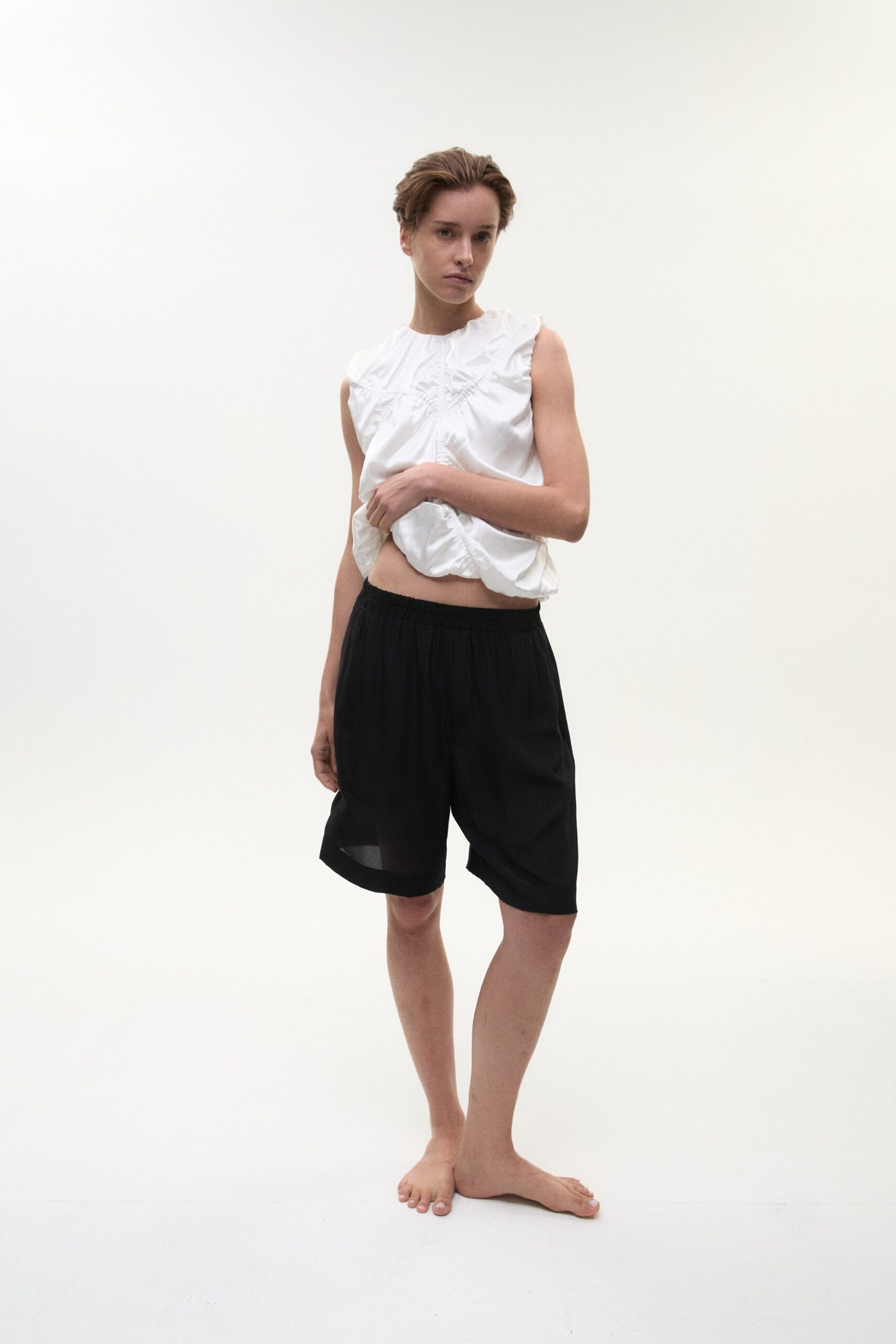 white ruffled top and black shorts