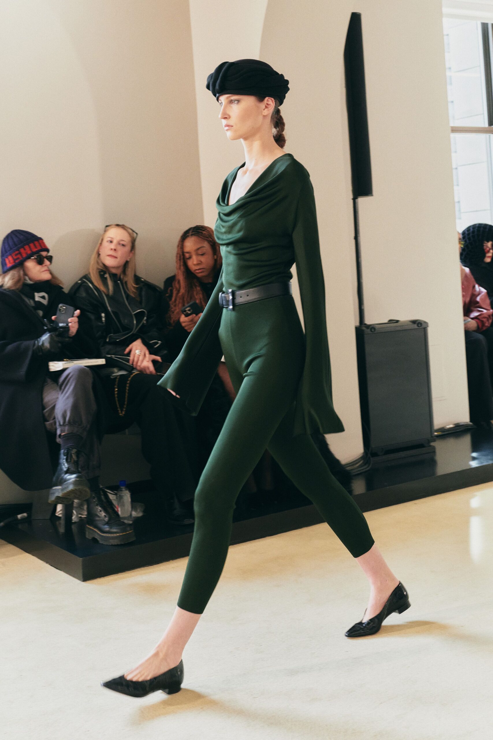 green fitted jumpsuit with black accessories
