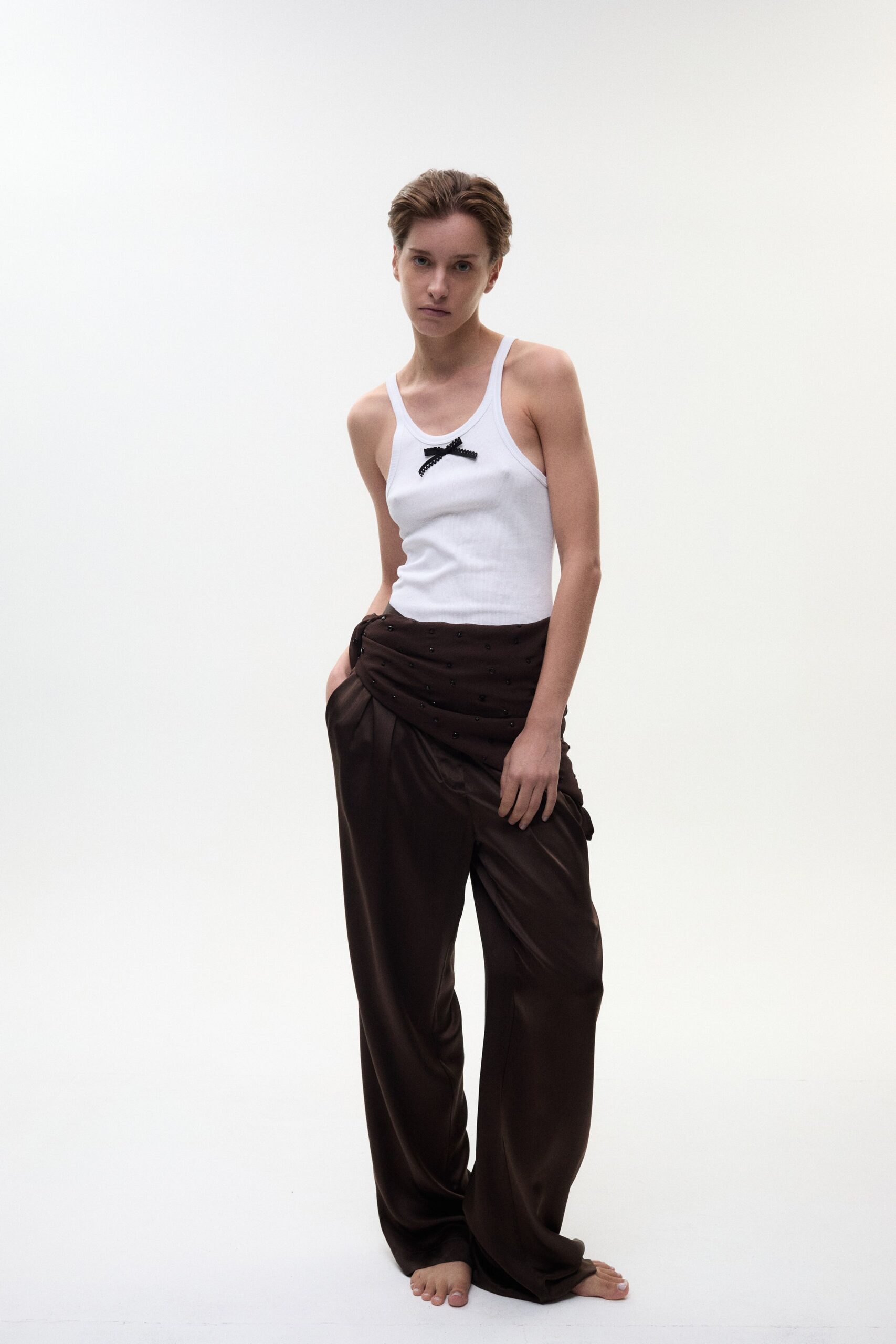 white tank-top and brown pleated pants
