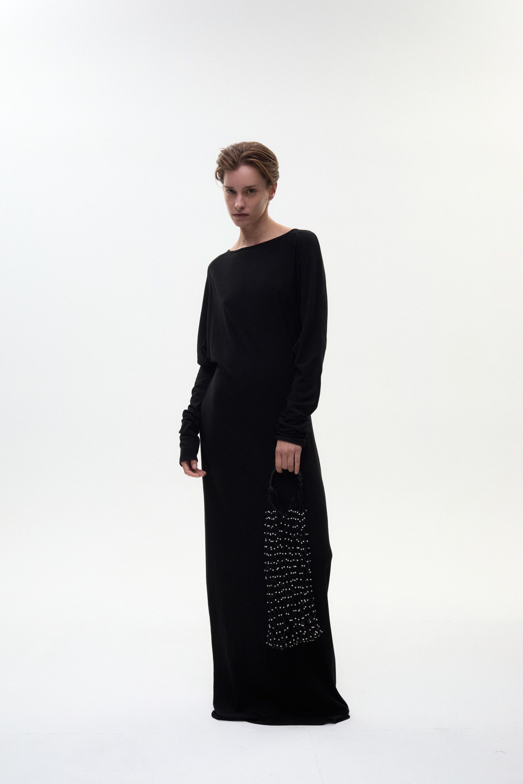 black fitted long-sleeve gown with beaded bag