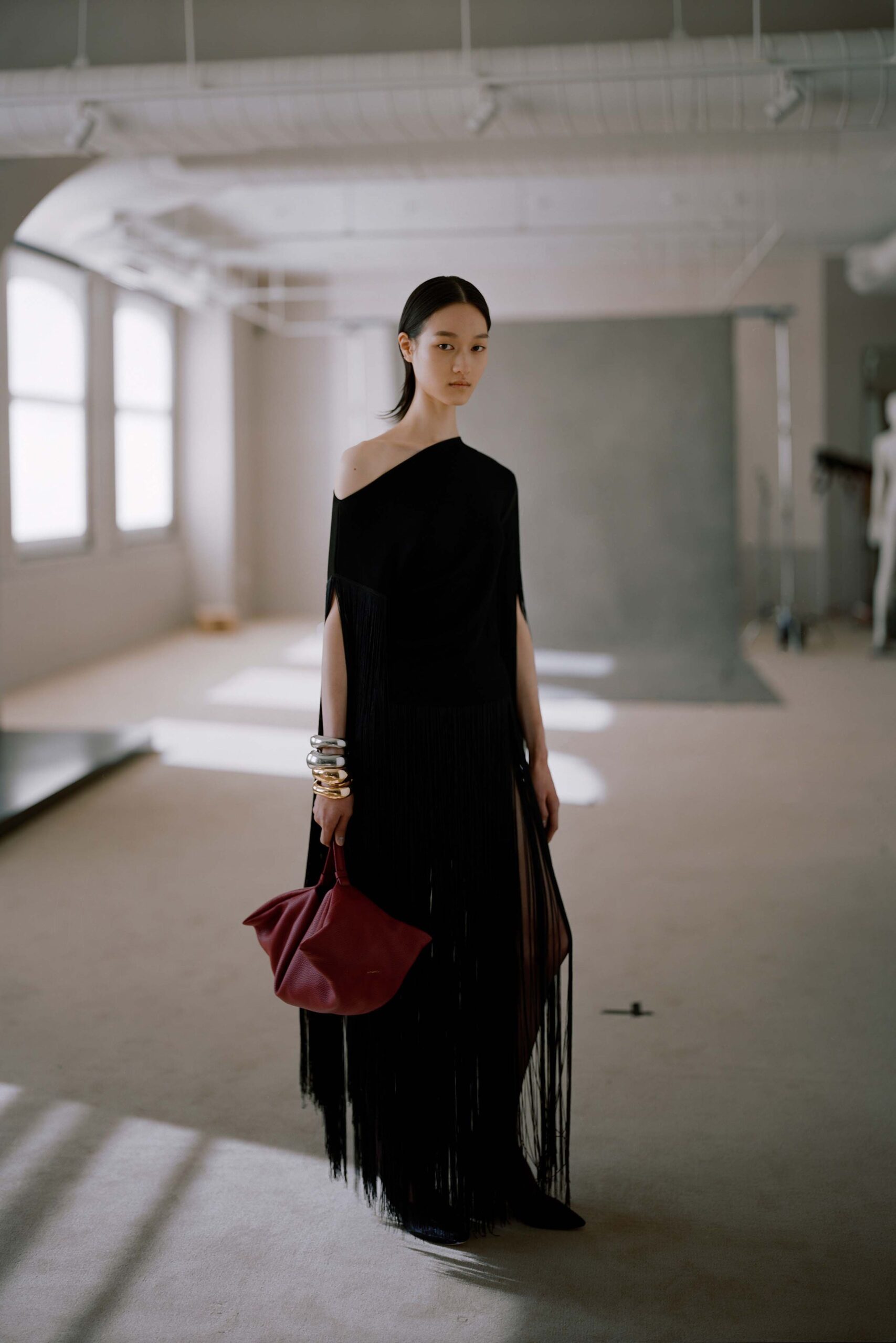 black fringed maxi dress with red bag