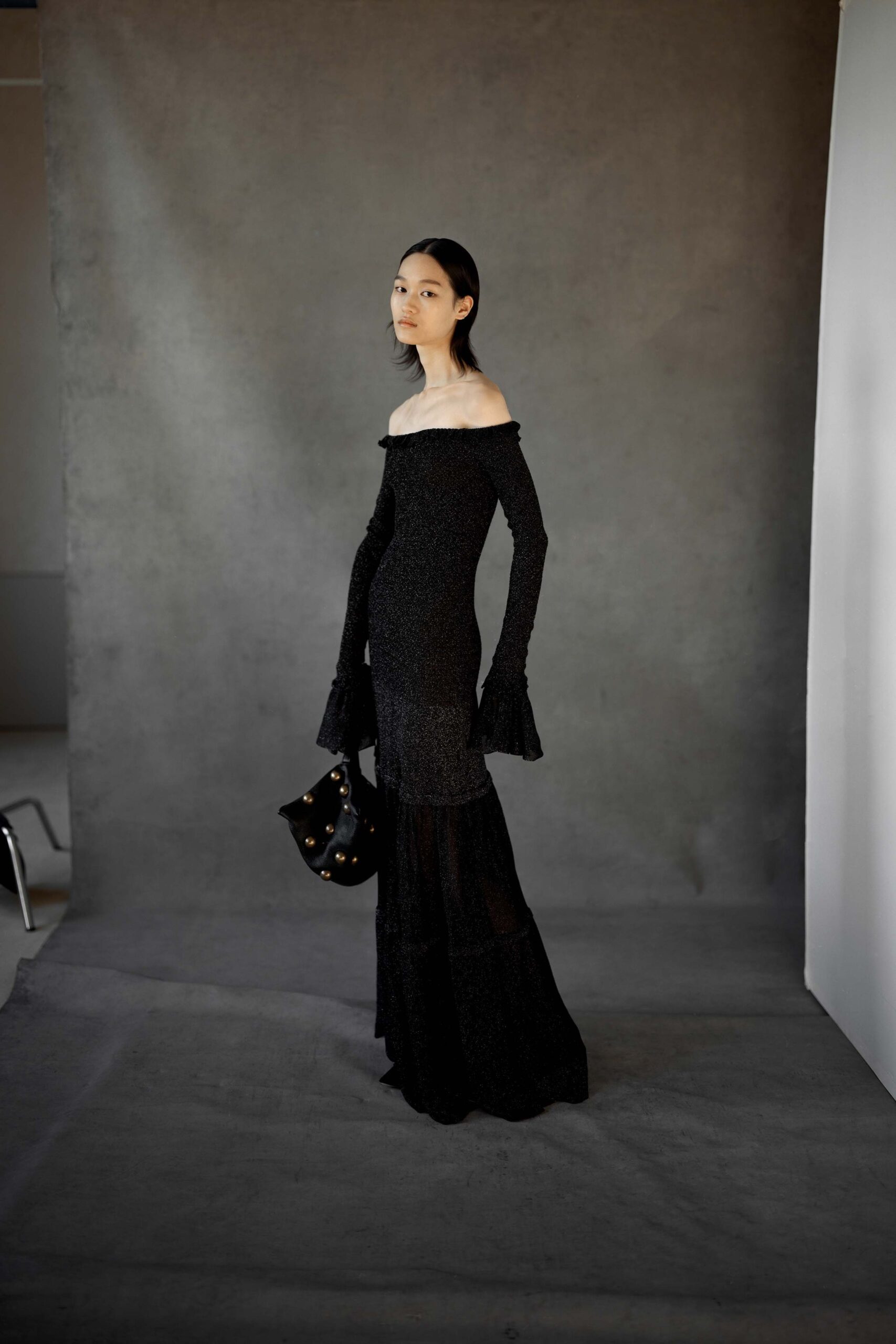 black off-shoulder gown with embellished bag