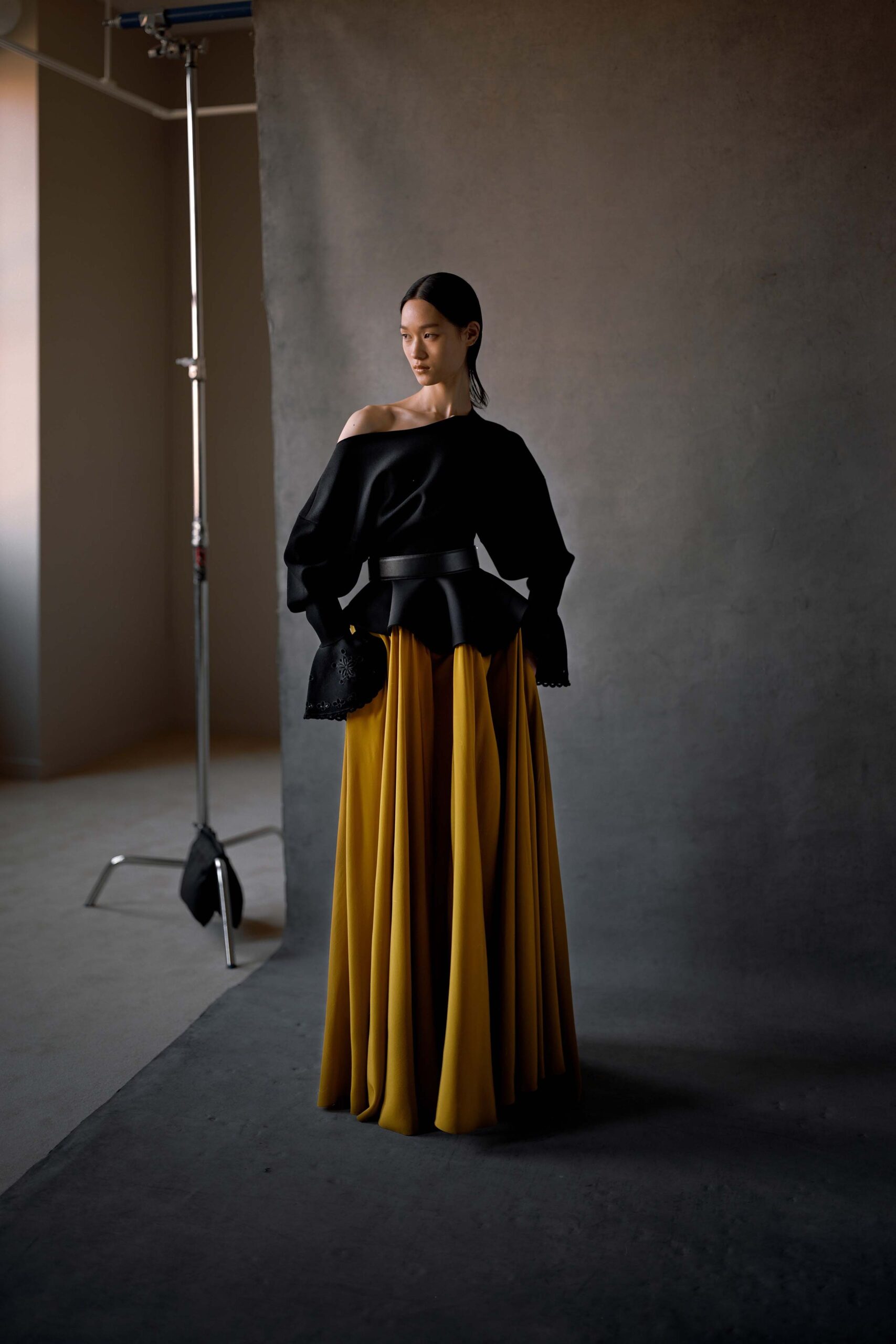 black silk off-shoulder top with yellow tiered skirt