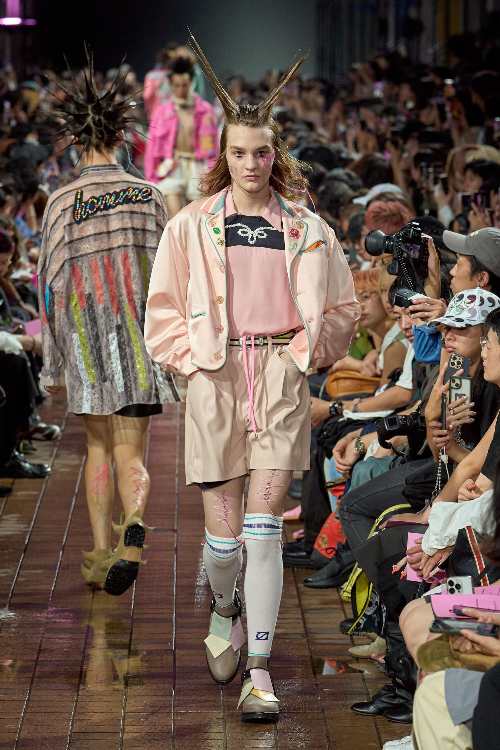 pink jacket black t-shirt beige shorts