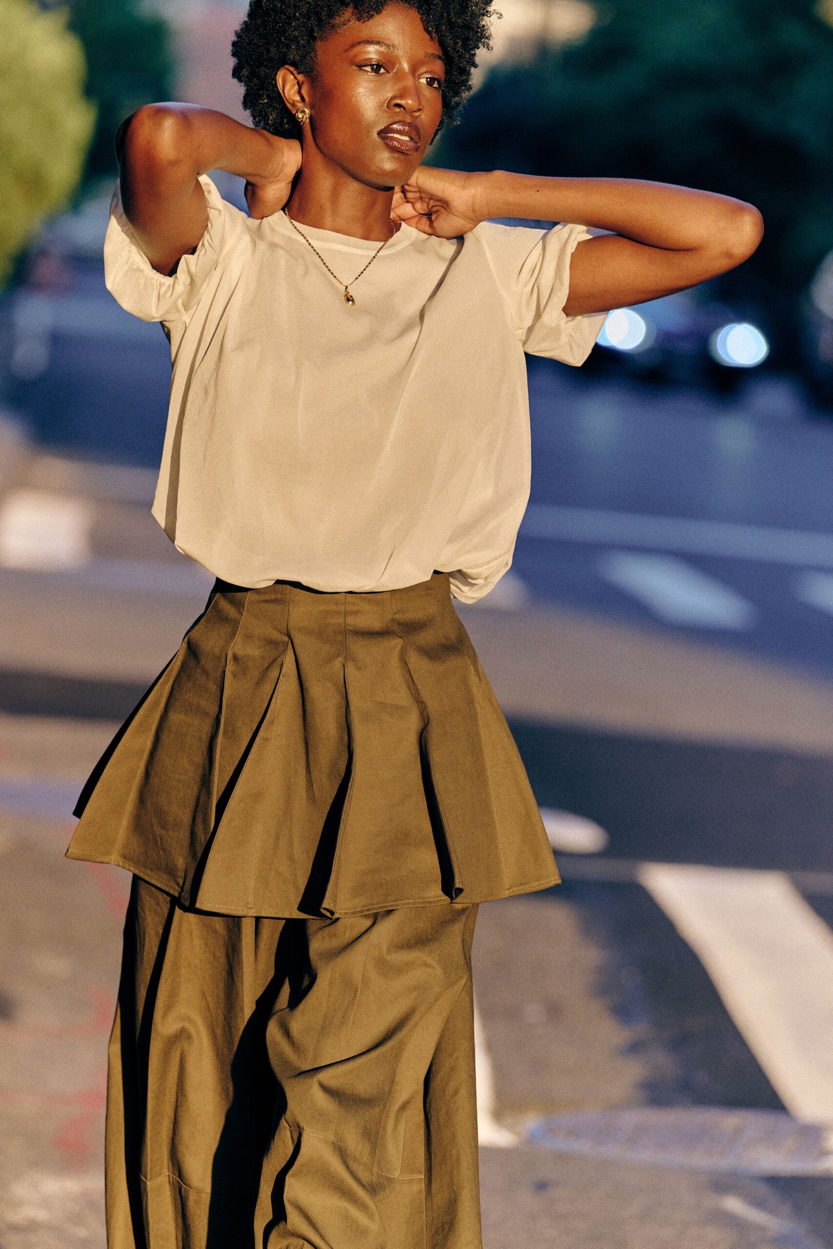 beige relaxed top with green pleated pants