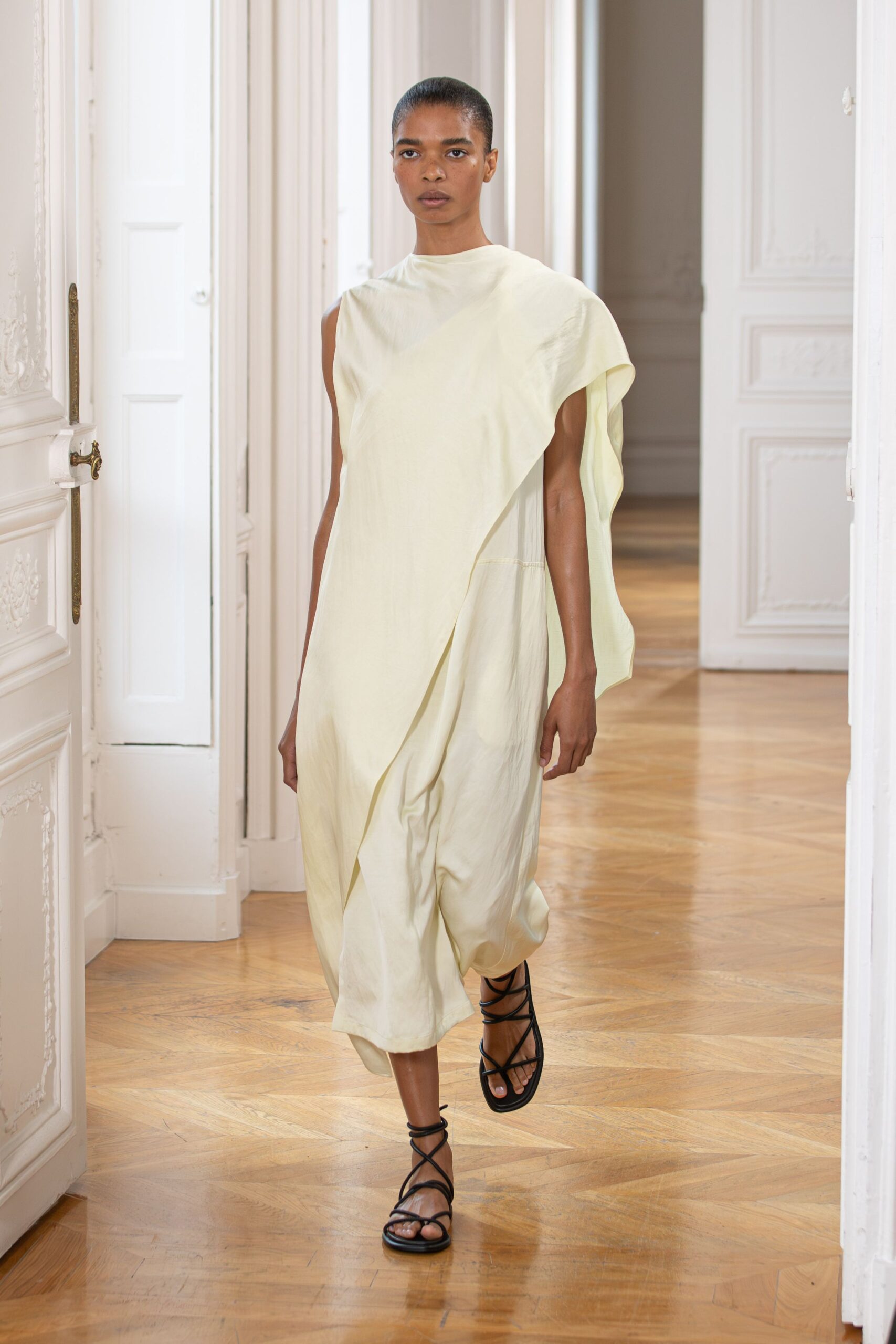yellow asymmetric draped dress with black shoes