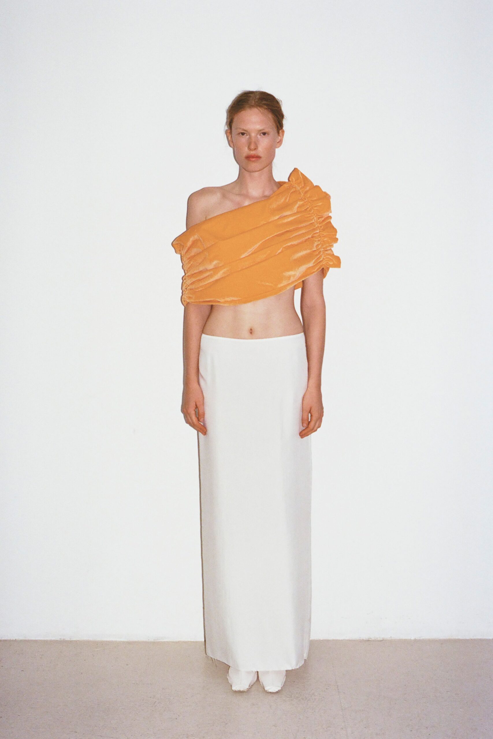 orange off-shoulder top with white maxi skirt