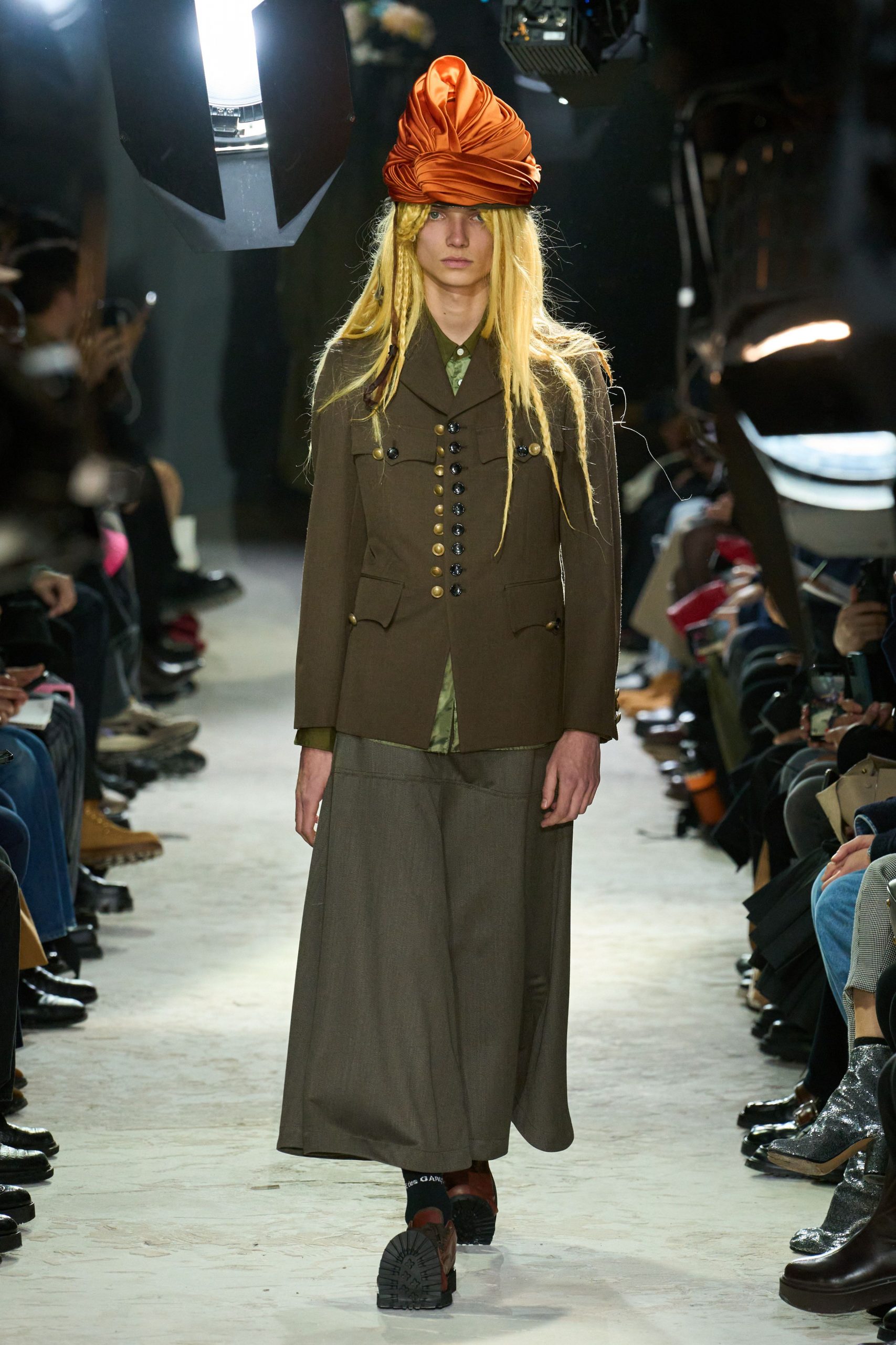 brown jacket green shirt gray pants orange hat