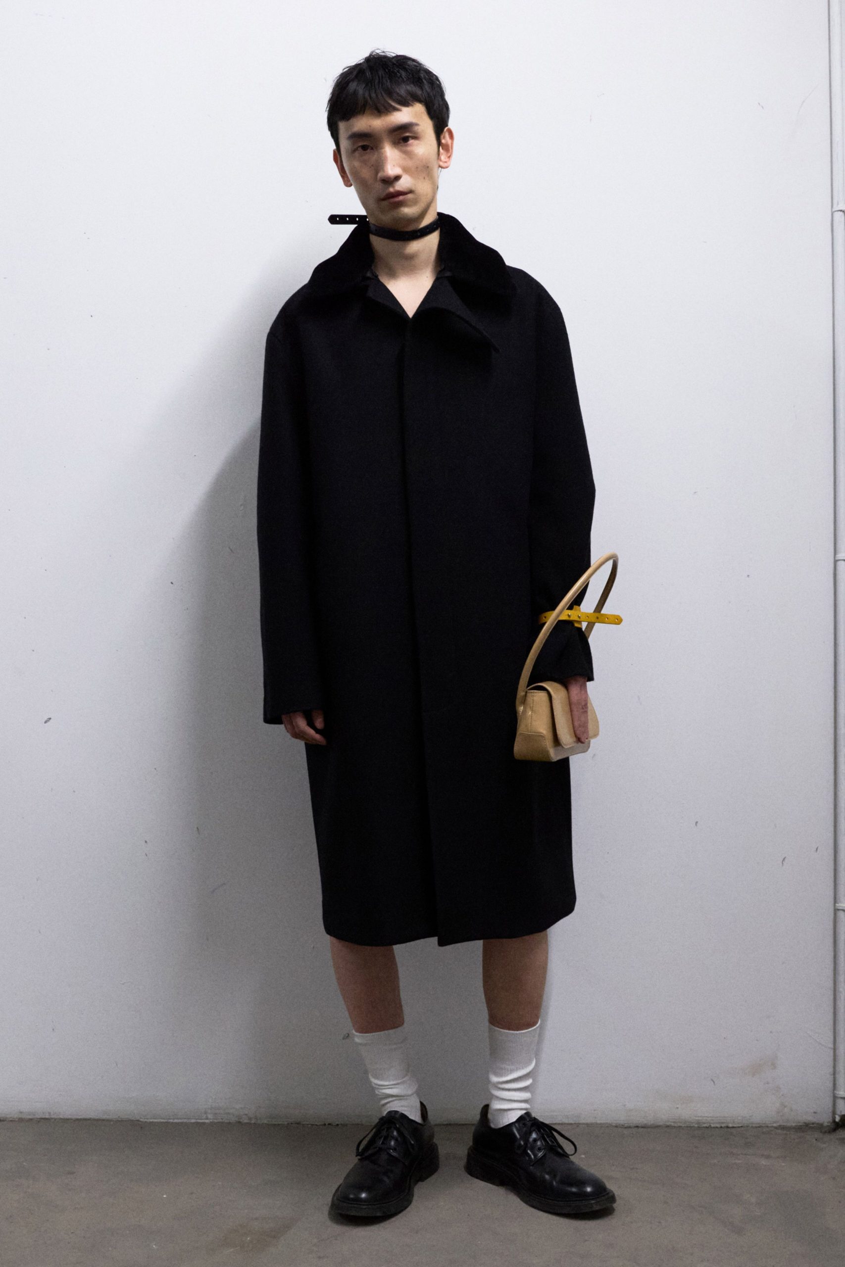 black wool coat with tan bag