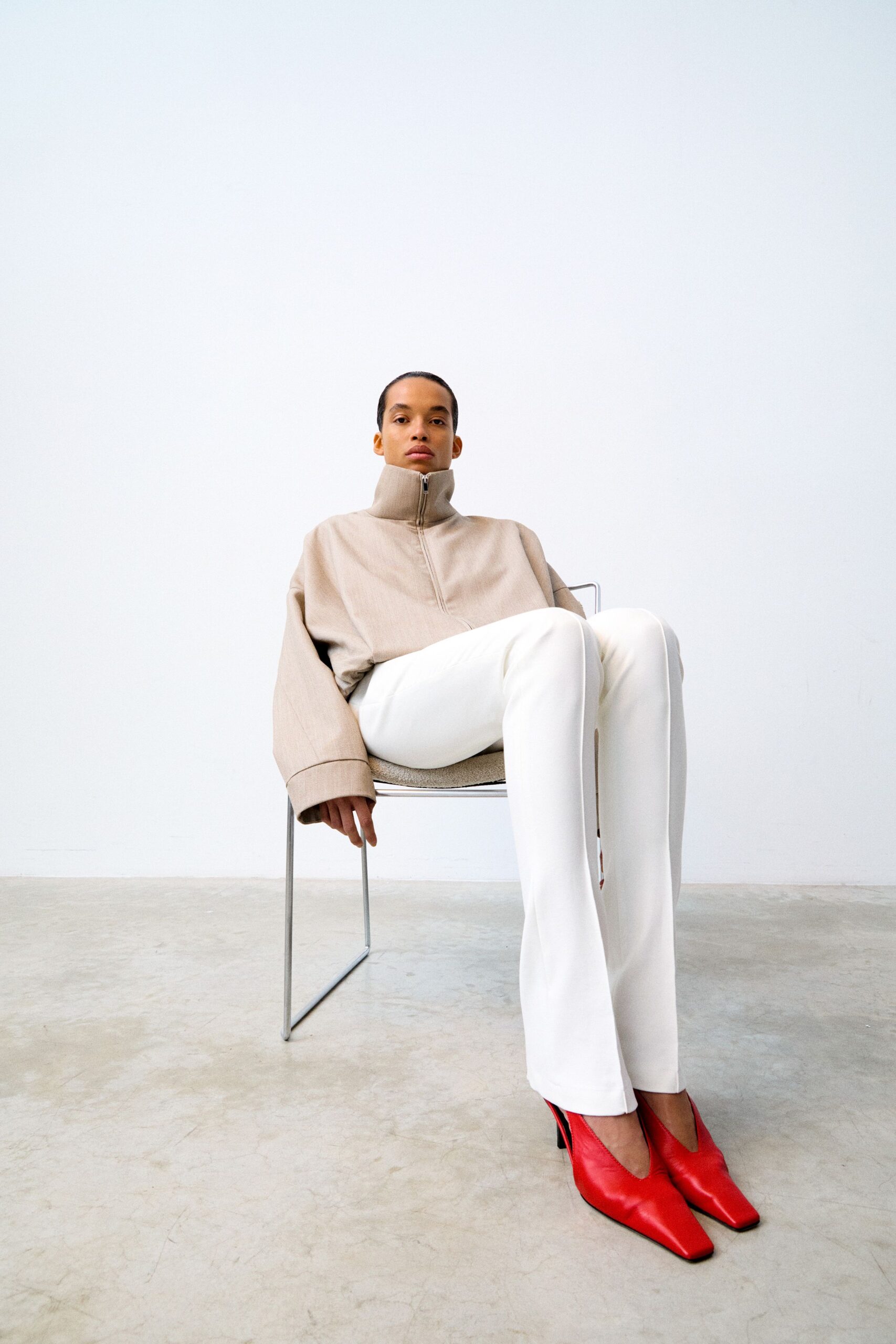 beige relaxed top with white fitted pants
