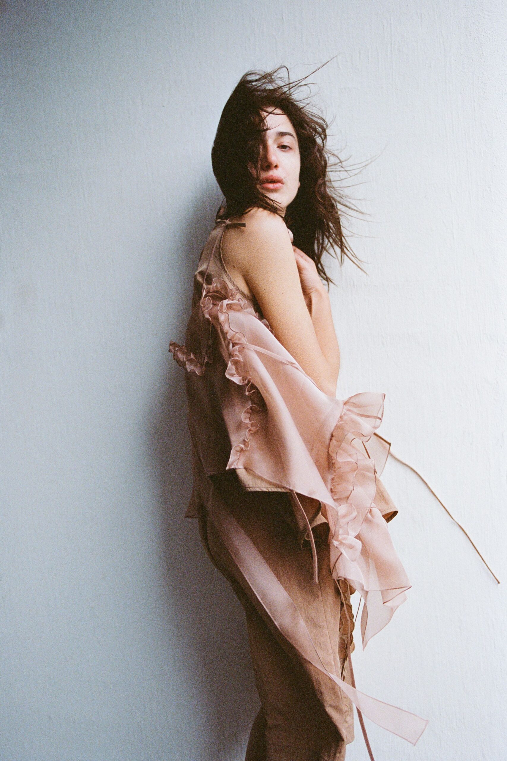 pink silk ruffled top with beige pants