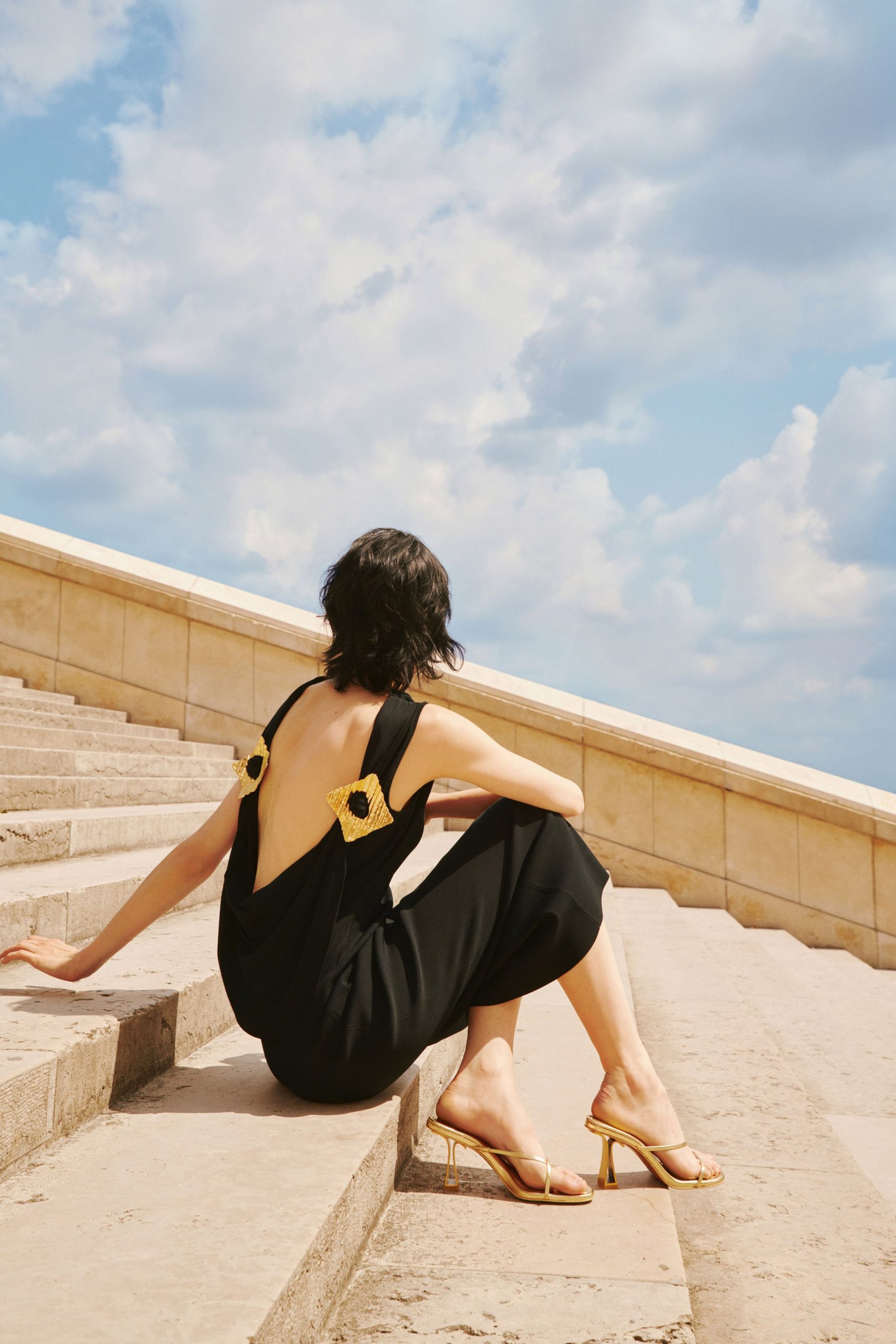 black silk backless dress with gold shoes