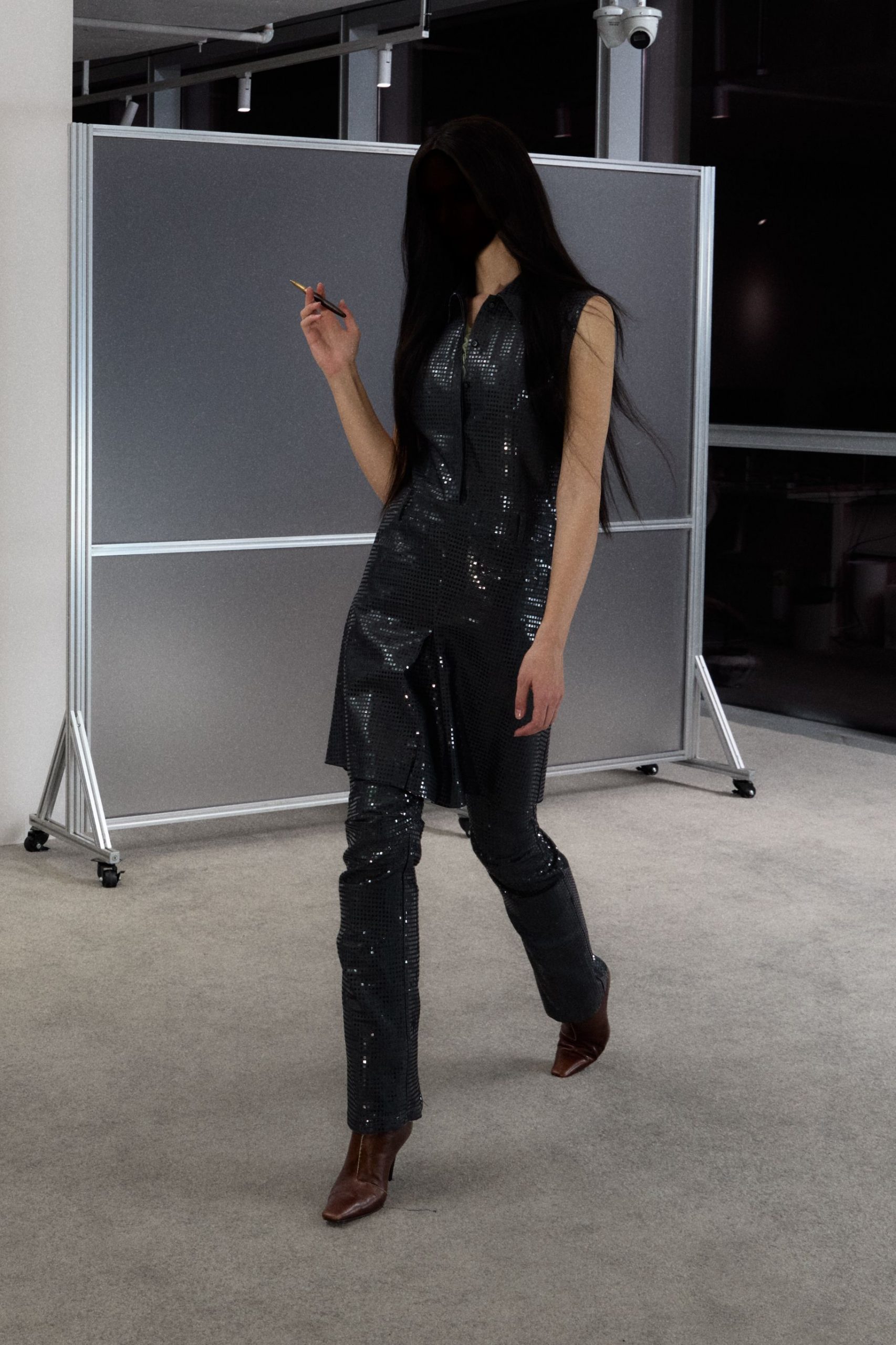 black vinyl sleeveless jumpsuit with brown boots