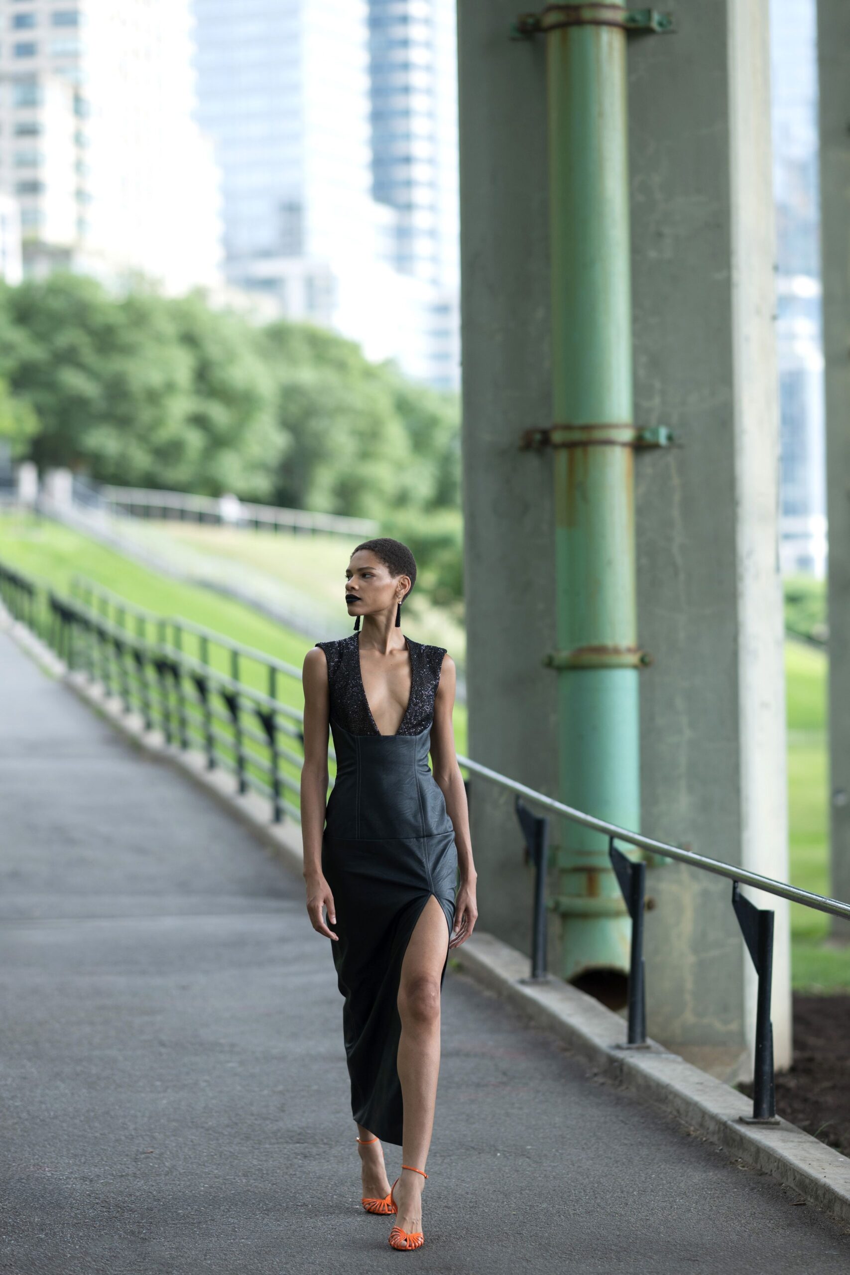 black leather sleeveless dress with orange shoes