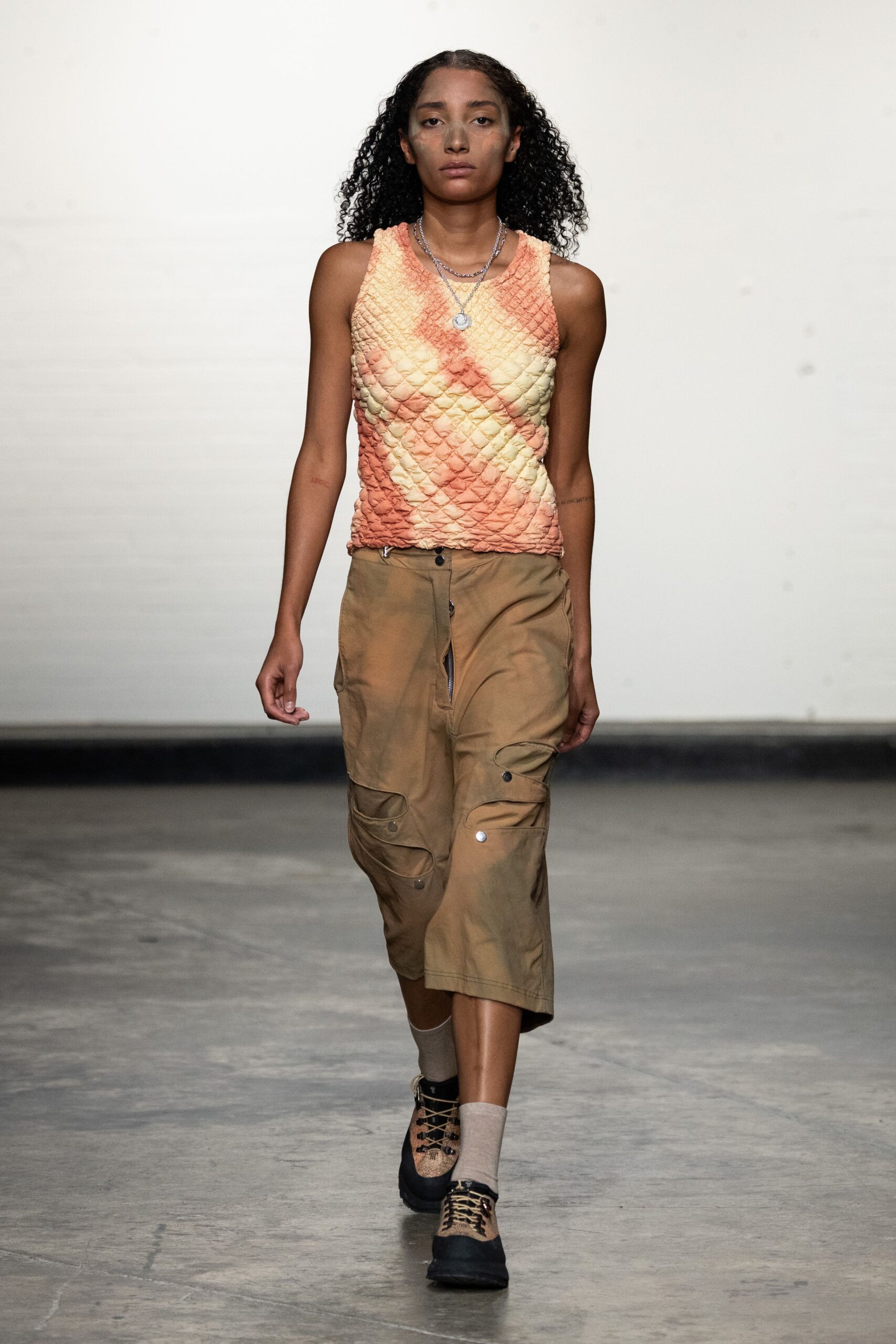orange quilted sleeveless top and brown midi skirt