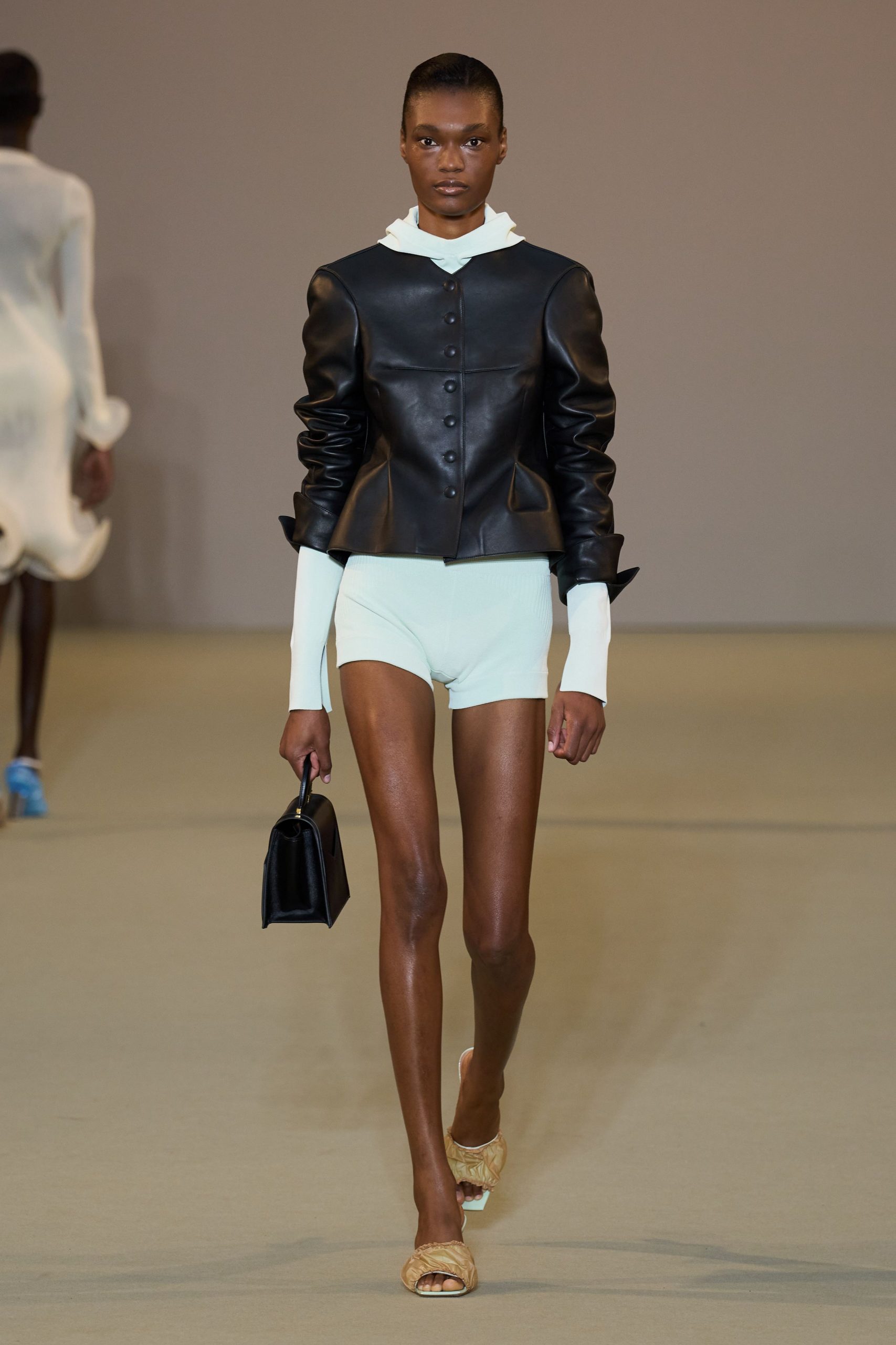 black leather fitted jacket with white shorts