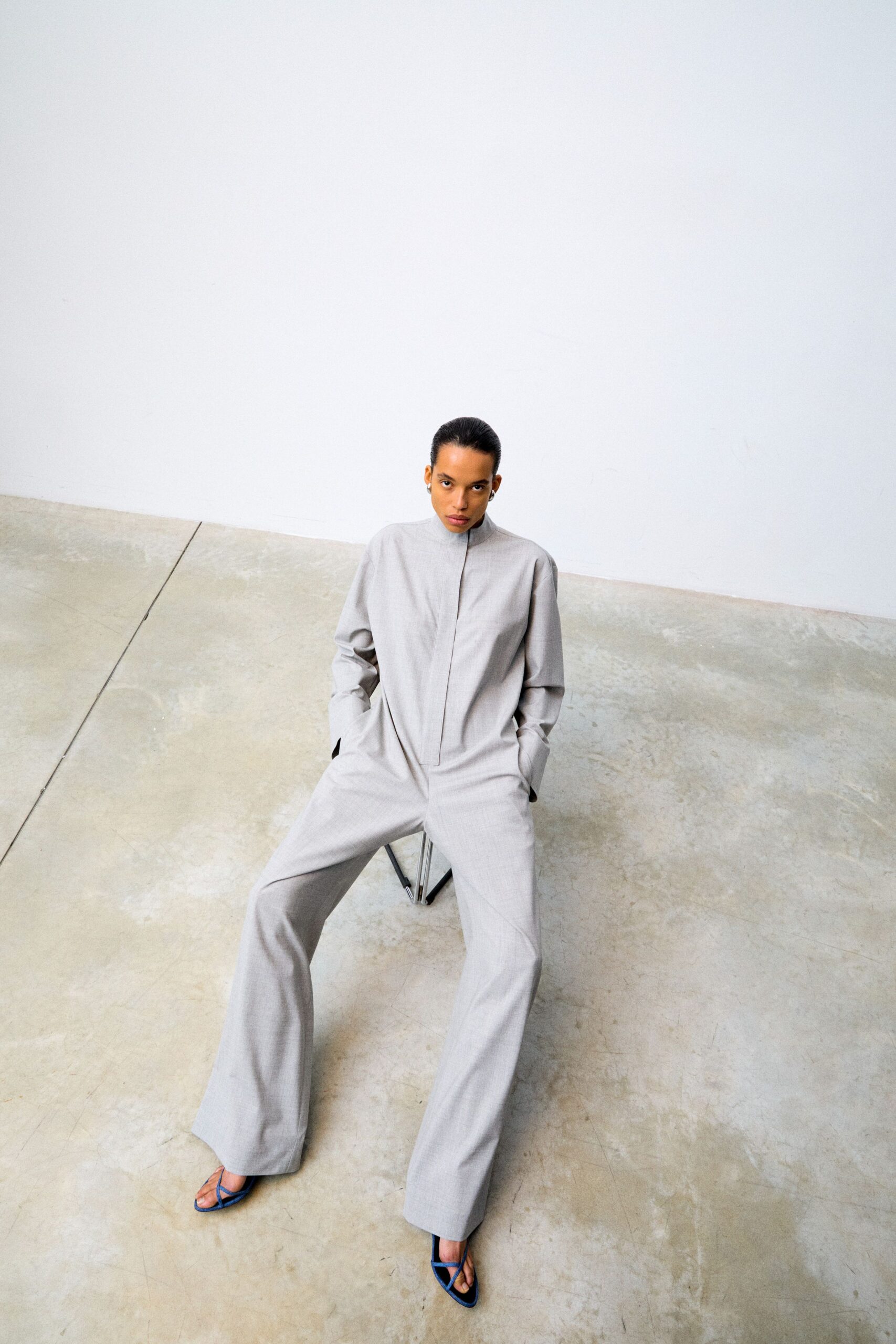 gray relaxed jumpsuit with blue shoes