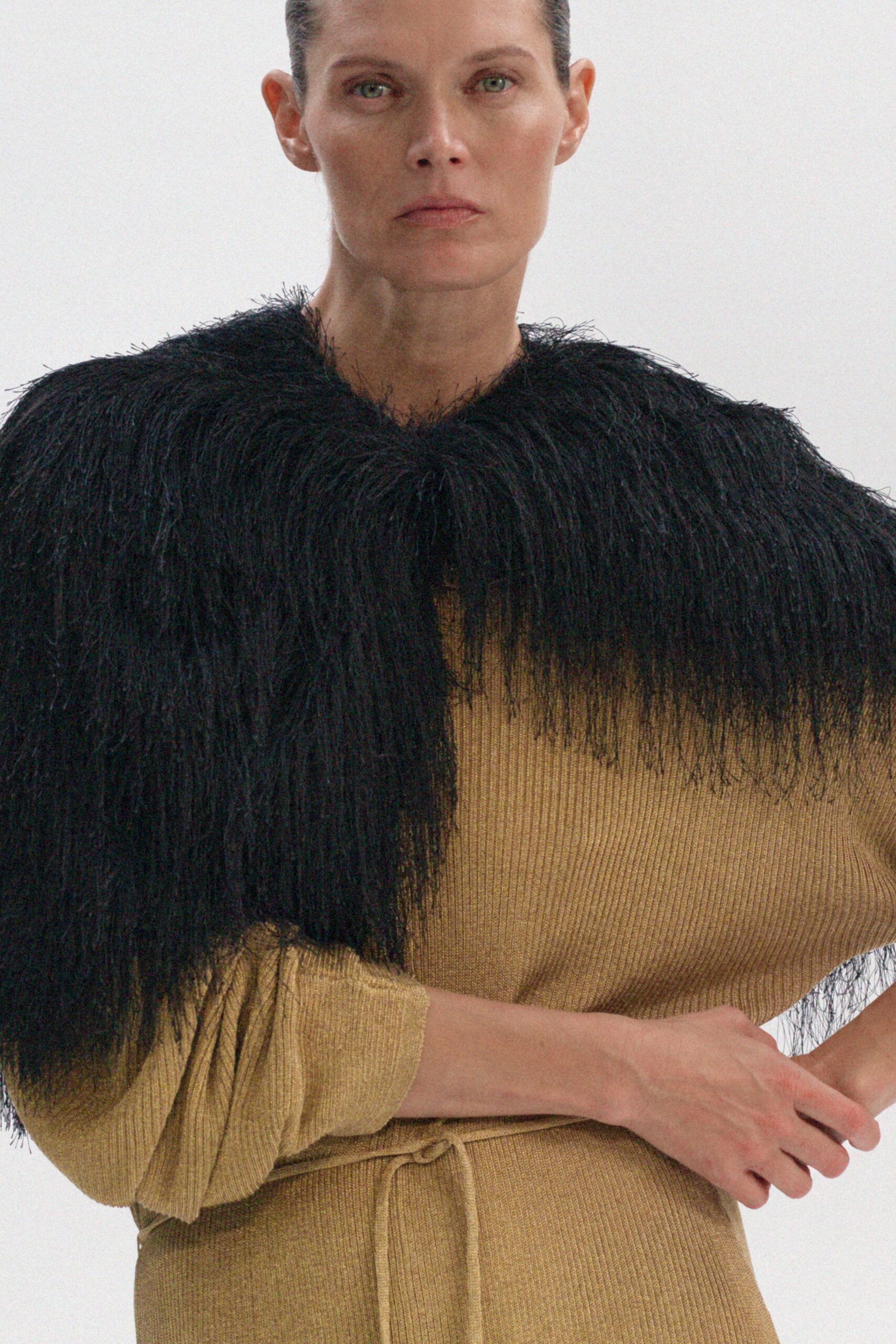 gold relaxed knit dress with black cape