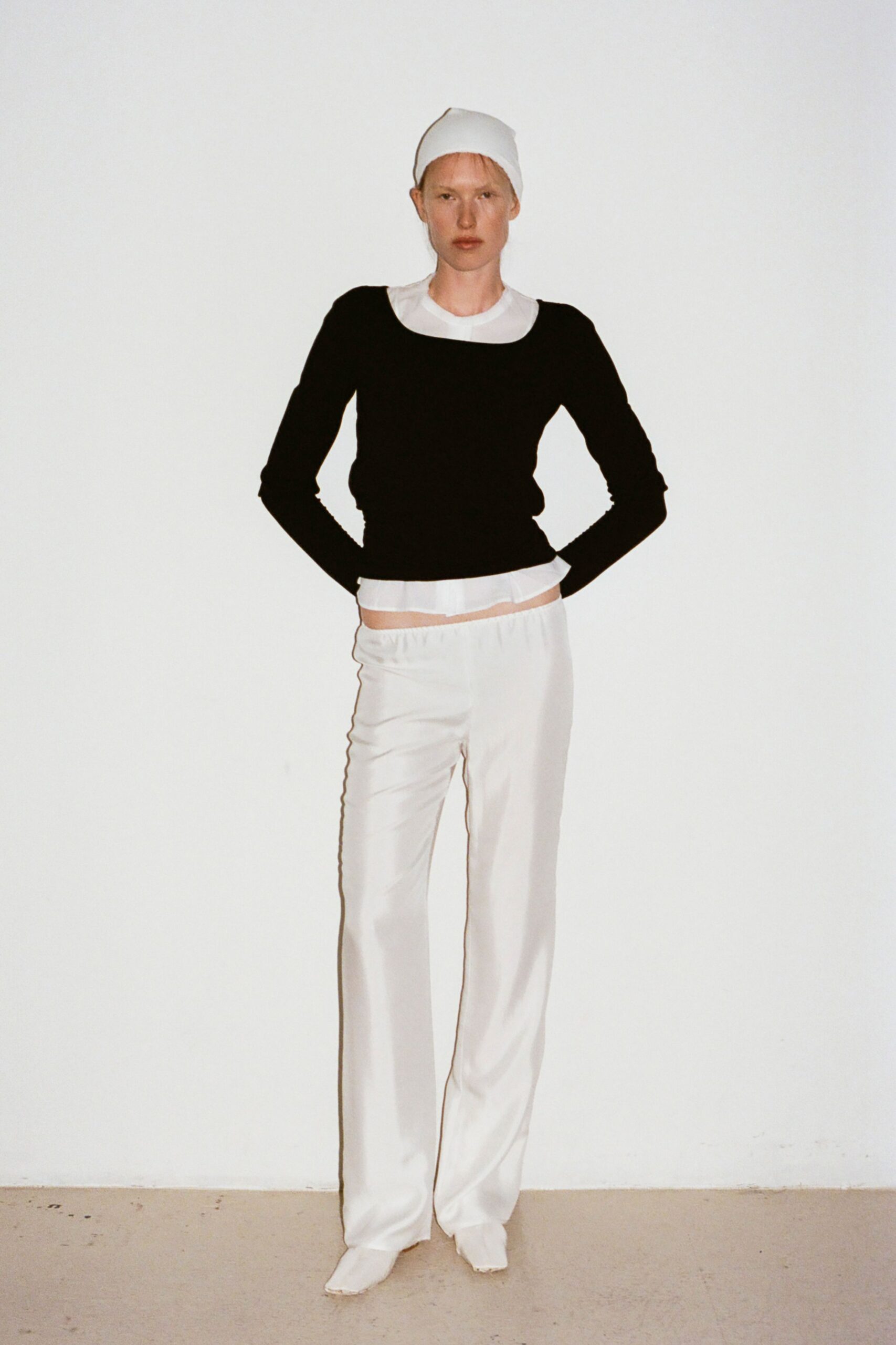 black fitted top and white pants