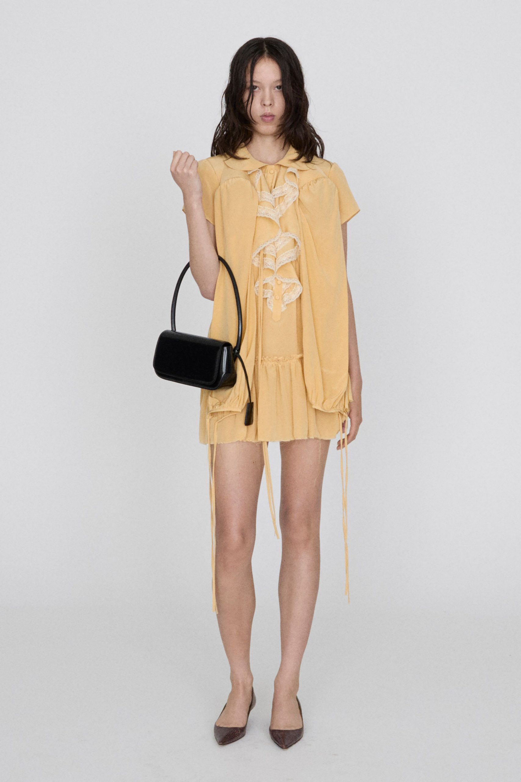 yellow mini dress with black bag