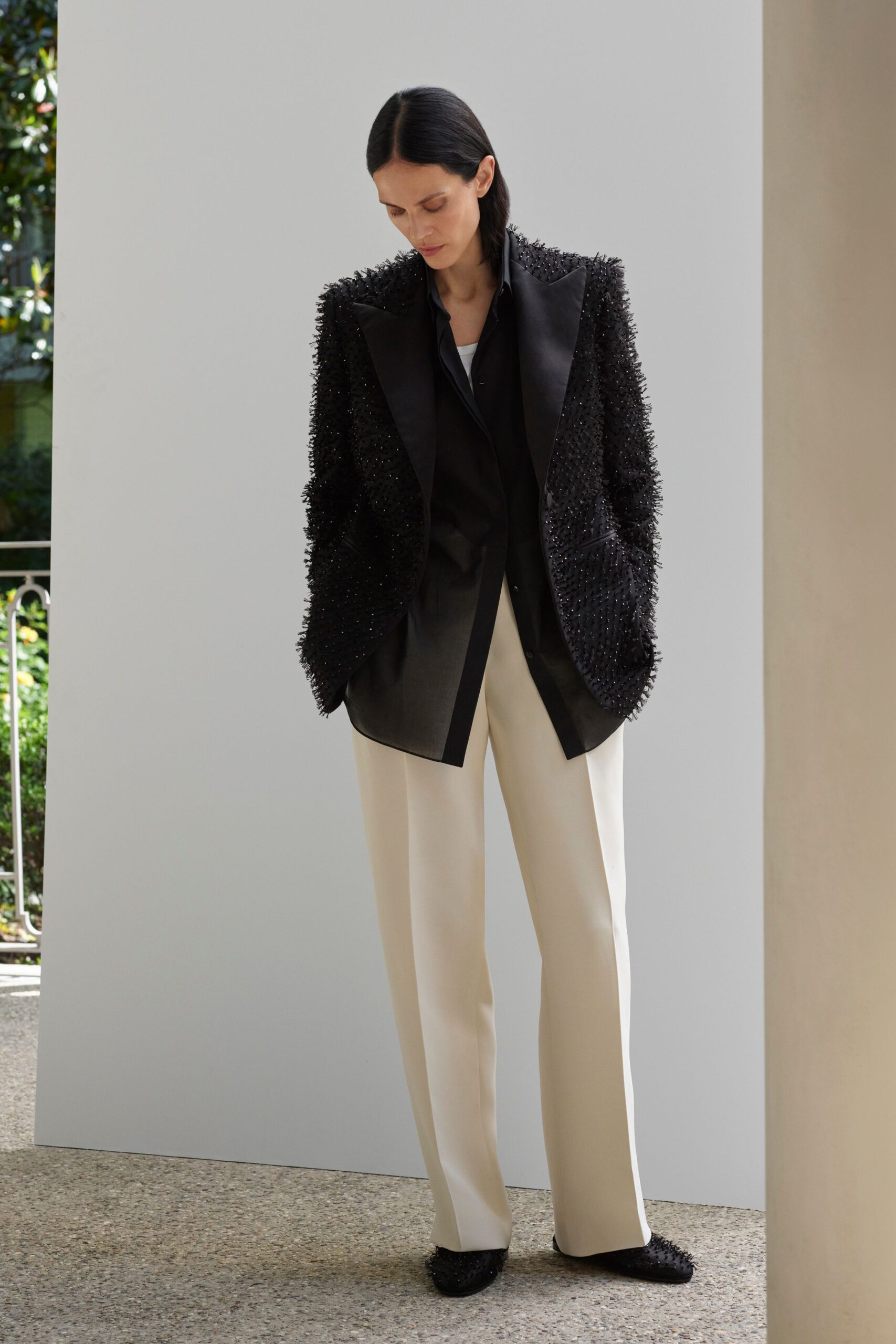 black beaded blazer with beige pants