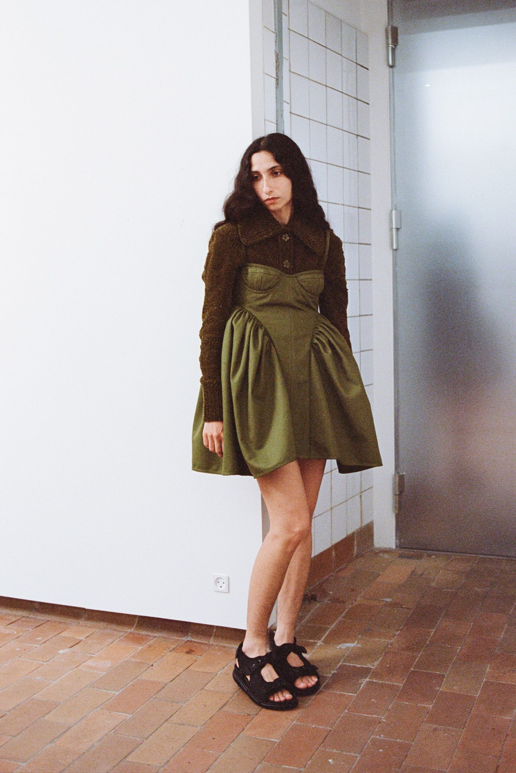 green pleated mini dress with black shoes