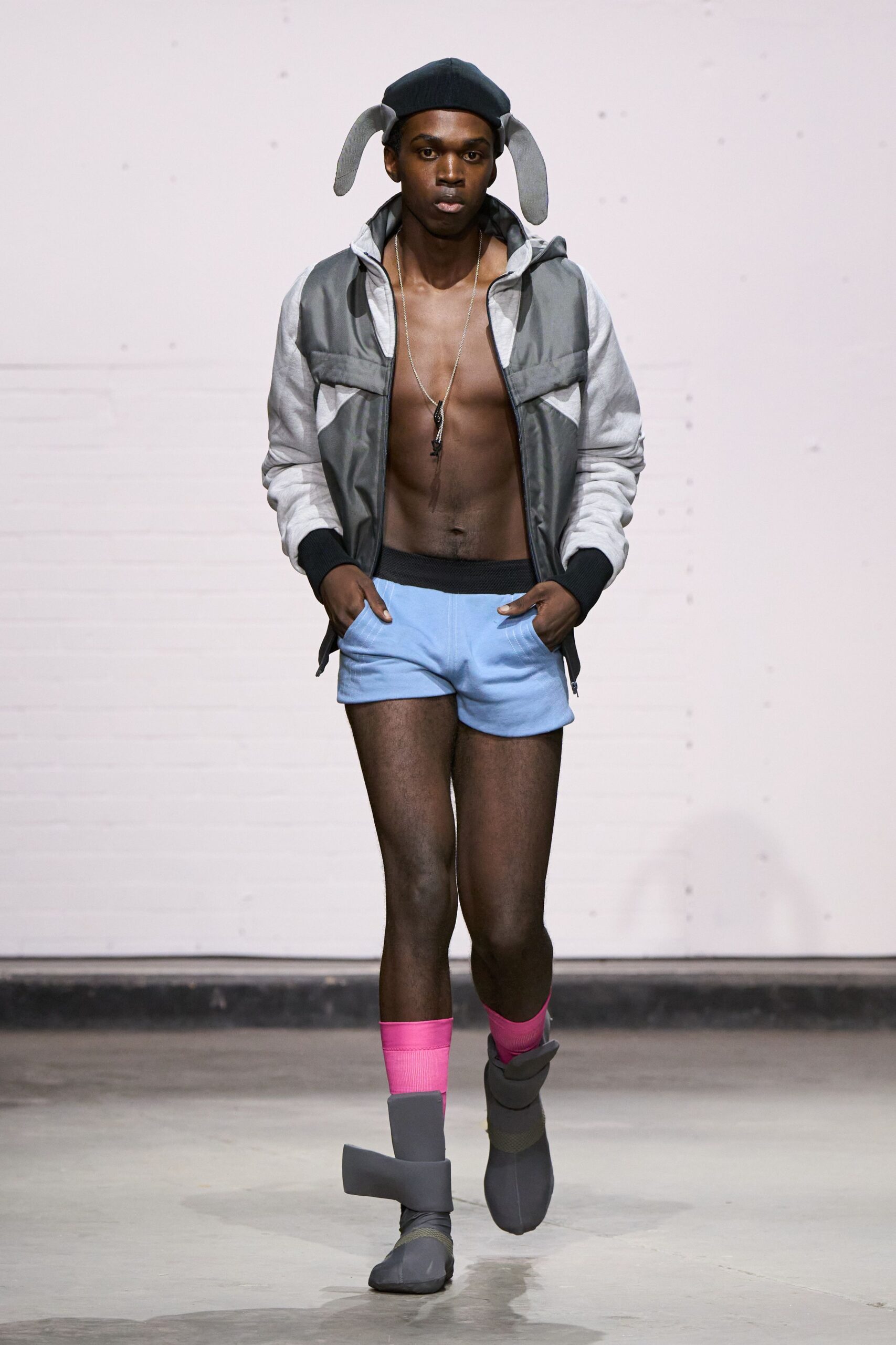 gray jacket black tank-top blue shorts