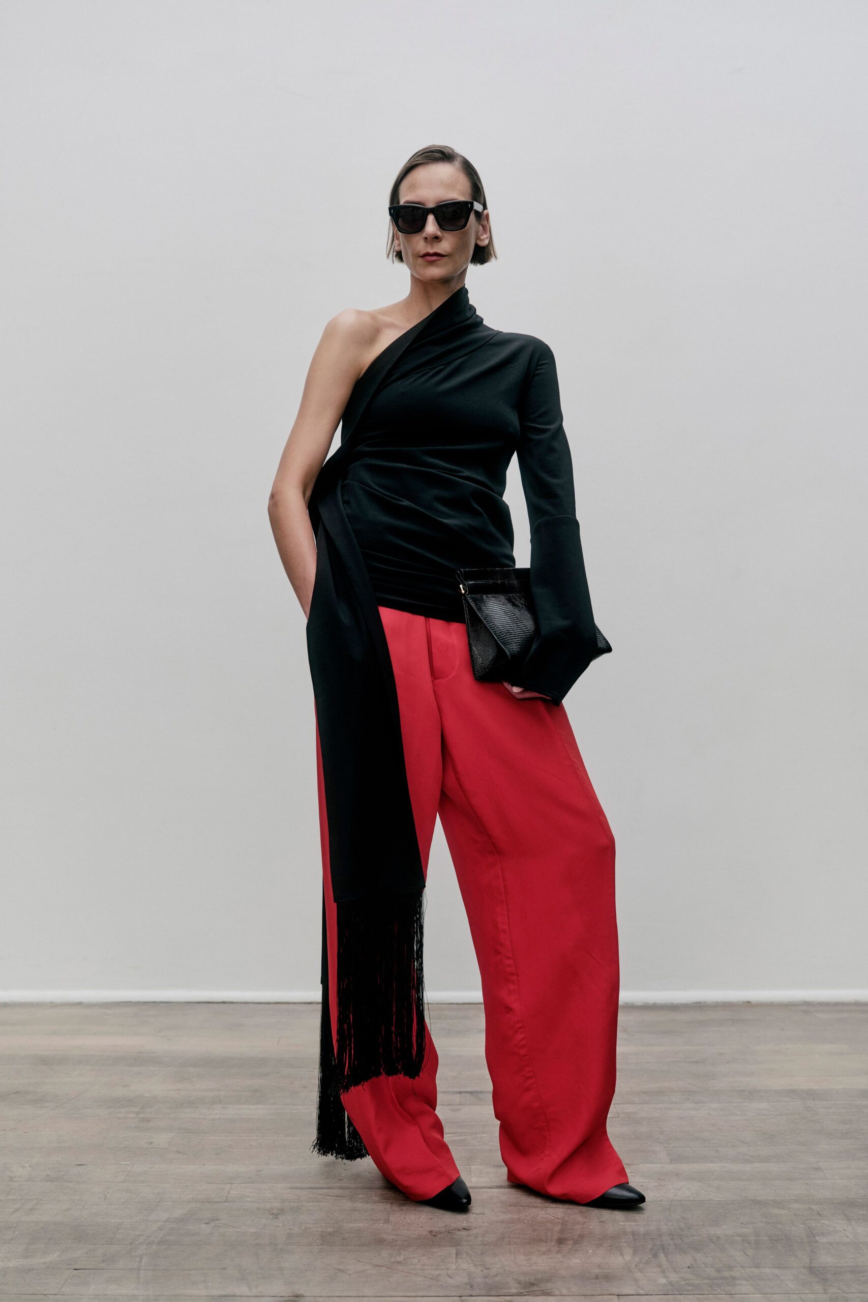 black asymmetric top with red pants