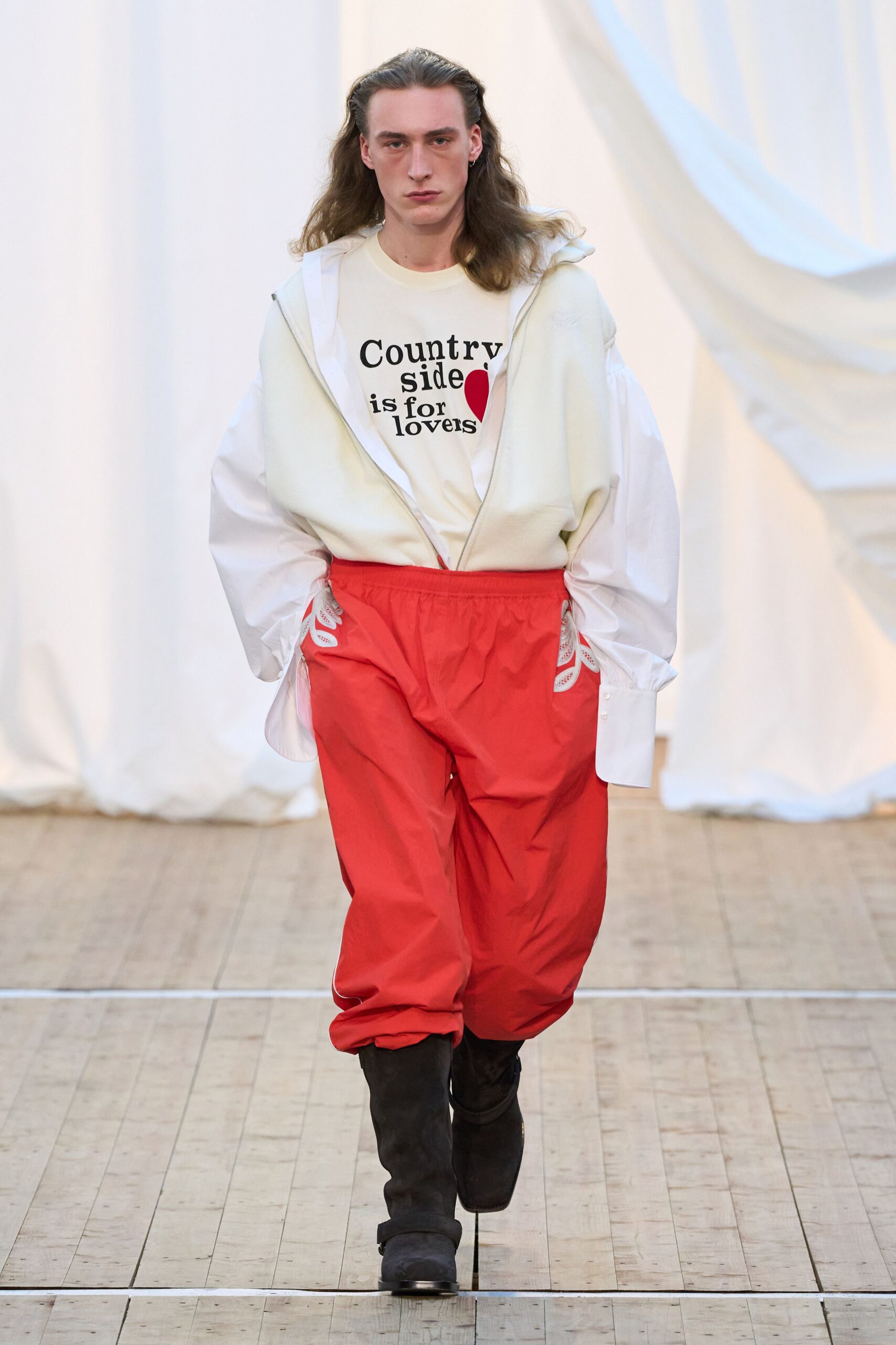white hoodie with printed shirt and red pants
