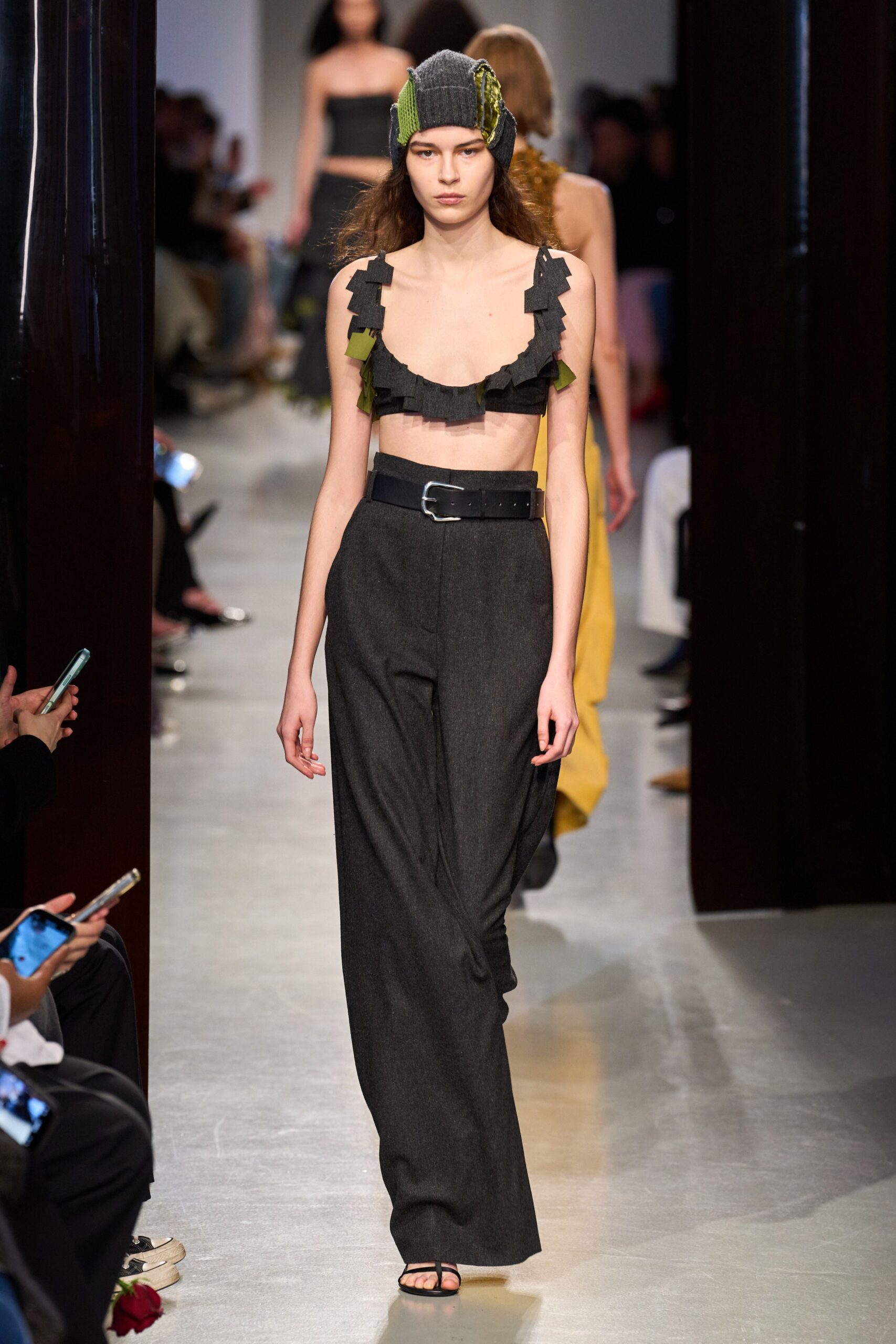 black and green ruffled top with gray pants