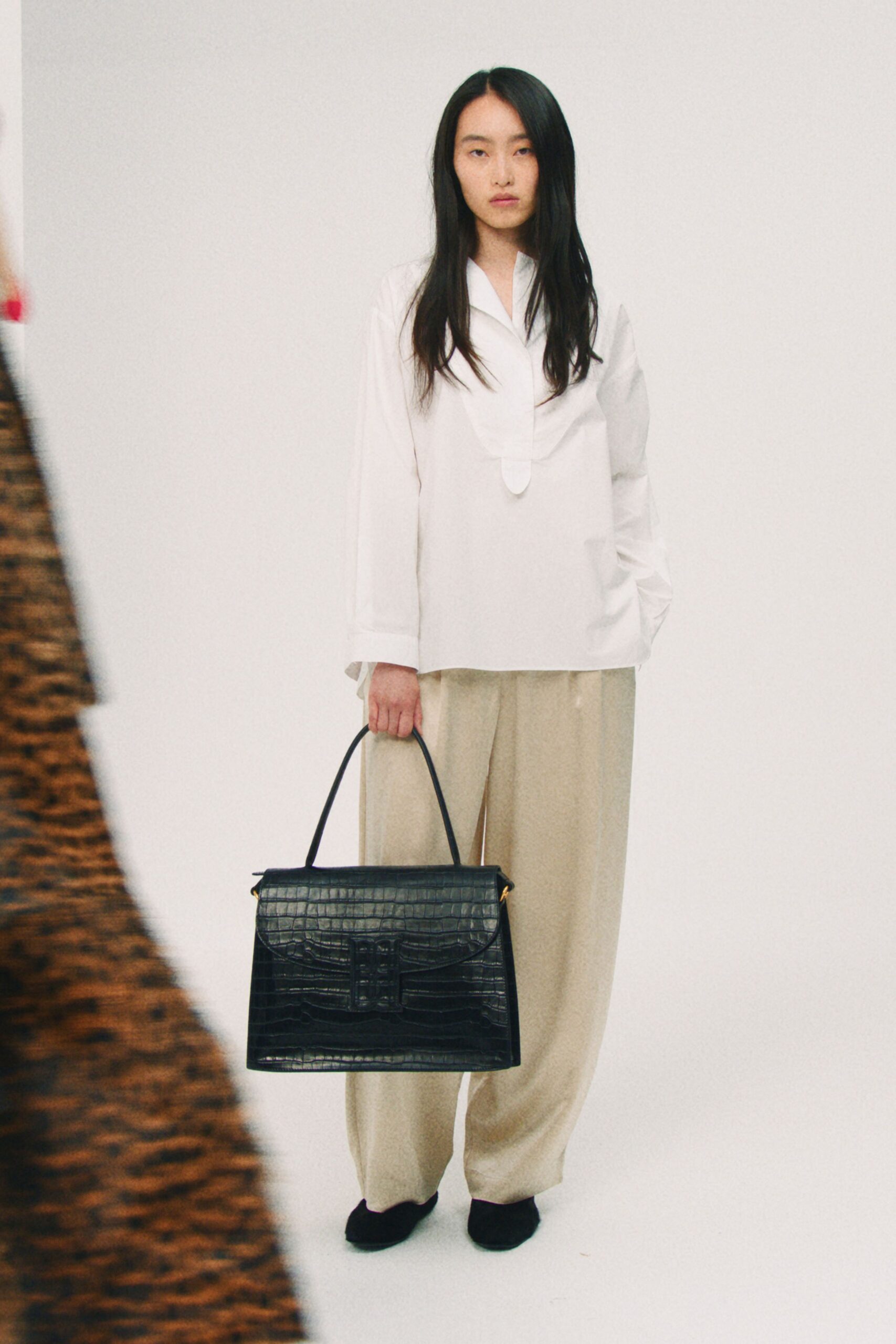 white shirt beige pants black bag