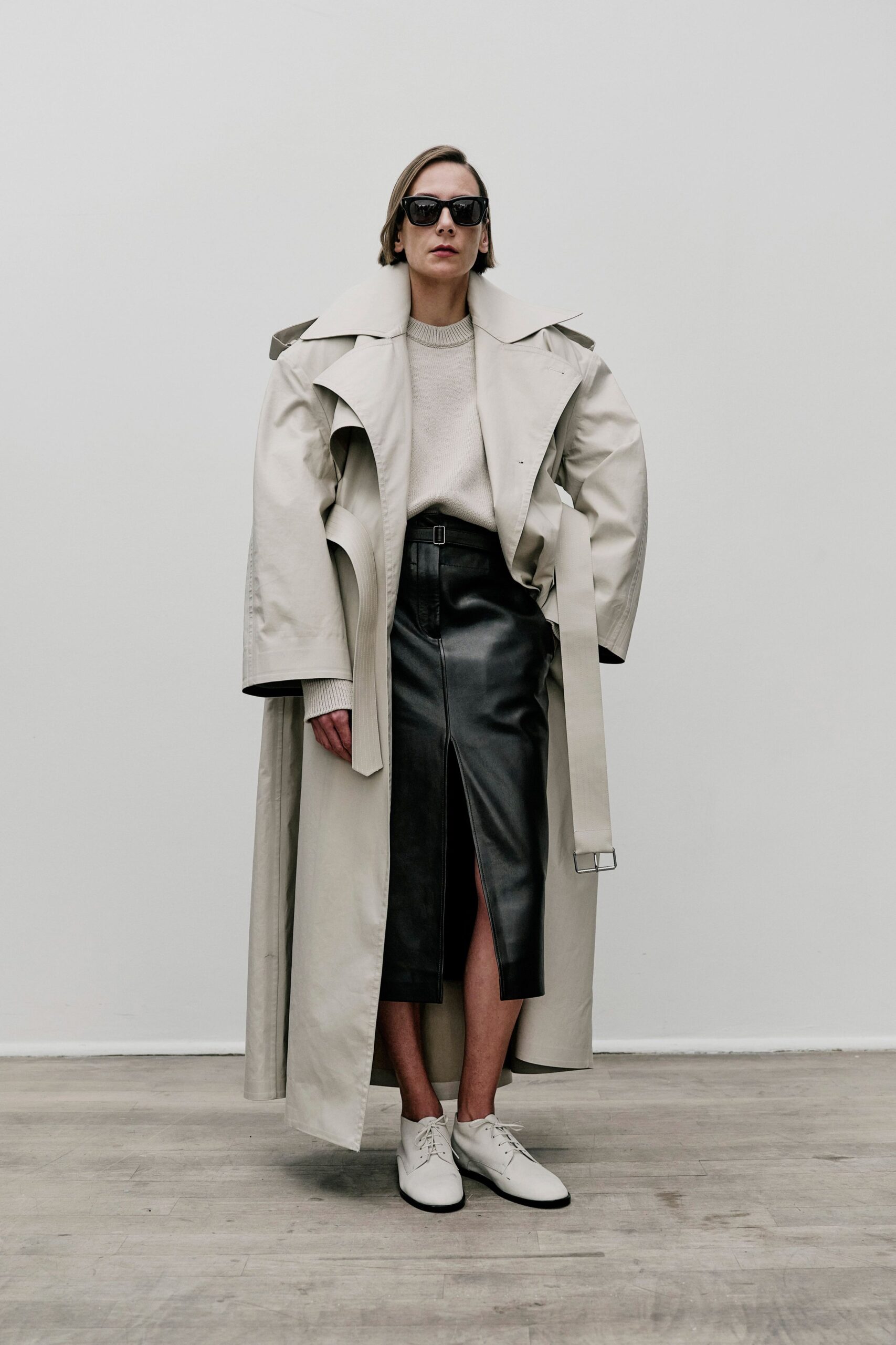 beige trench coat with black leather skirt